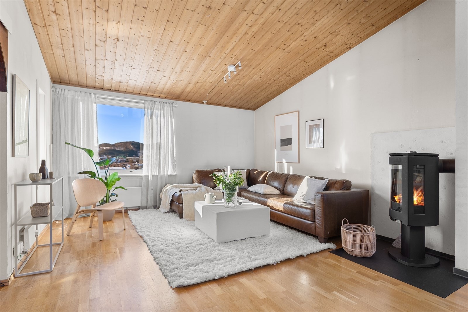 Lys og innbydende stue med peis og flott utsikt. Perfekt for avslapning og hygge i hjemmets hjerte. Galleribilde