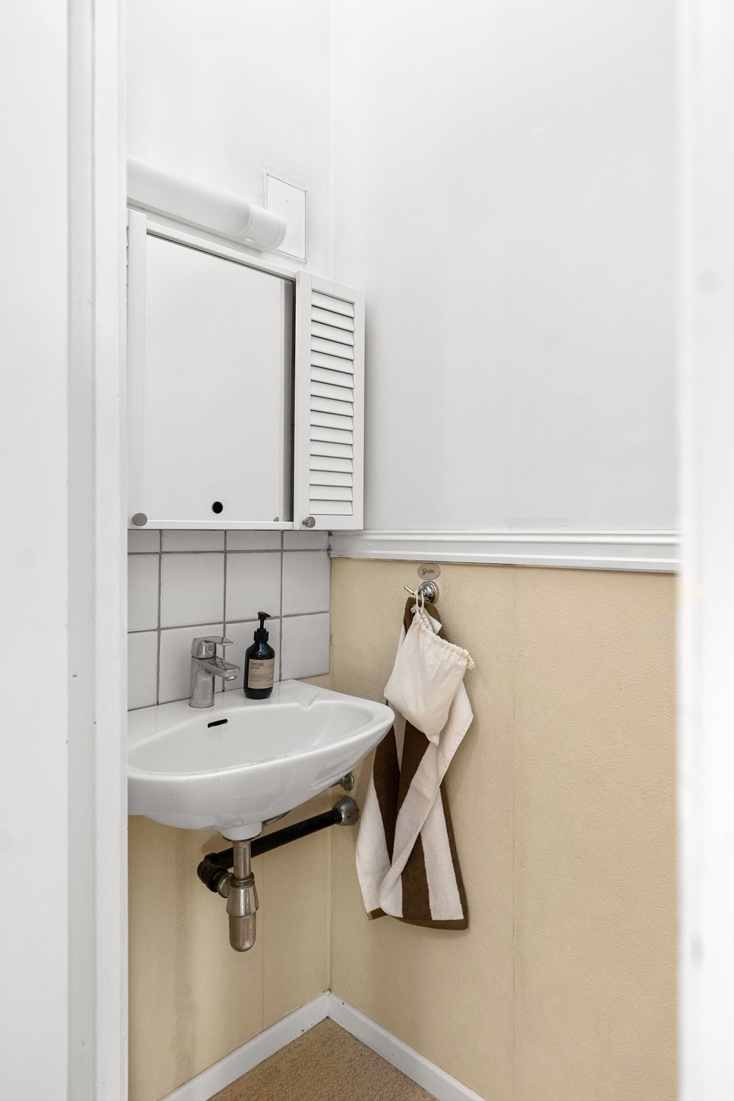 Praktisk toalettrom med servant og speilskap, ideelt for effektiv utnyttelse av mindre rom. Galleribilde