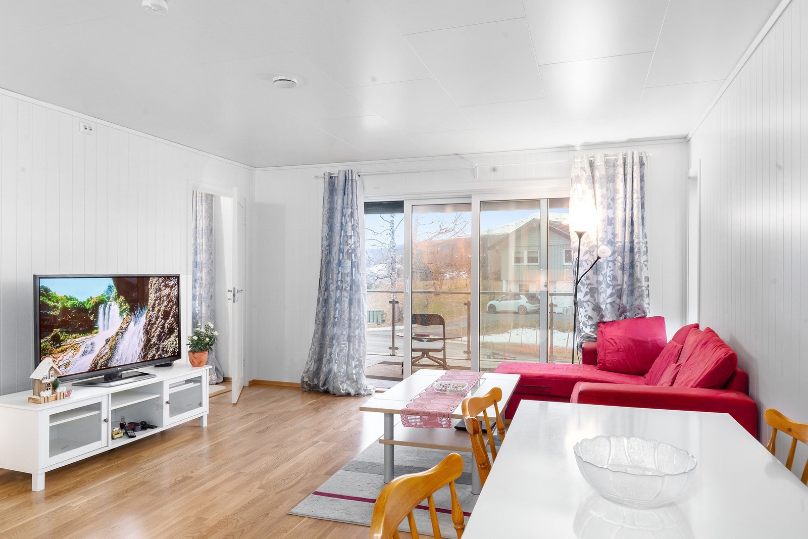 Stue delvis adskilt fra kjøkken på 23,5 kvm med store vindusflater og skyvedør ut til altan. Galleribilde