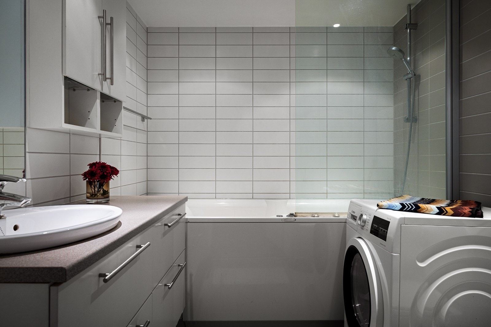 Baderommet ligger i tilknytning til hybeldelen. Baderommet er innredet med badekar, dusjhode, toalett, servantskap med glatte fronter og servantskål. Galleribilde