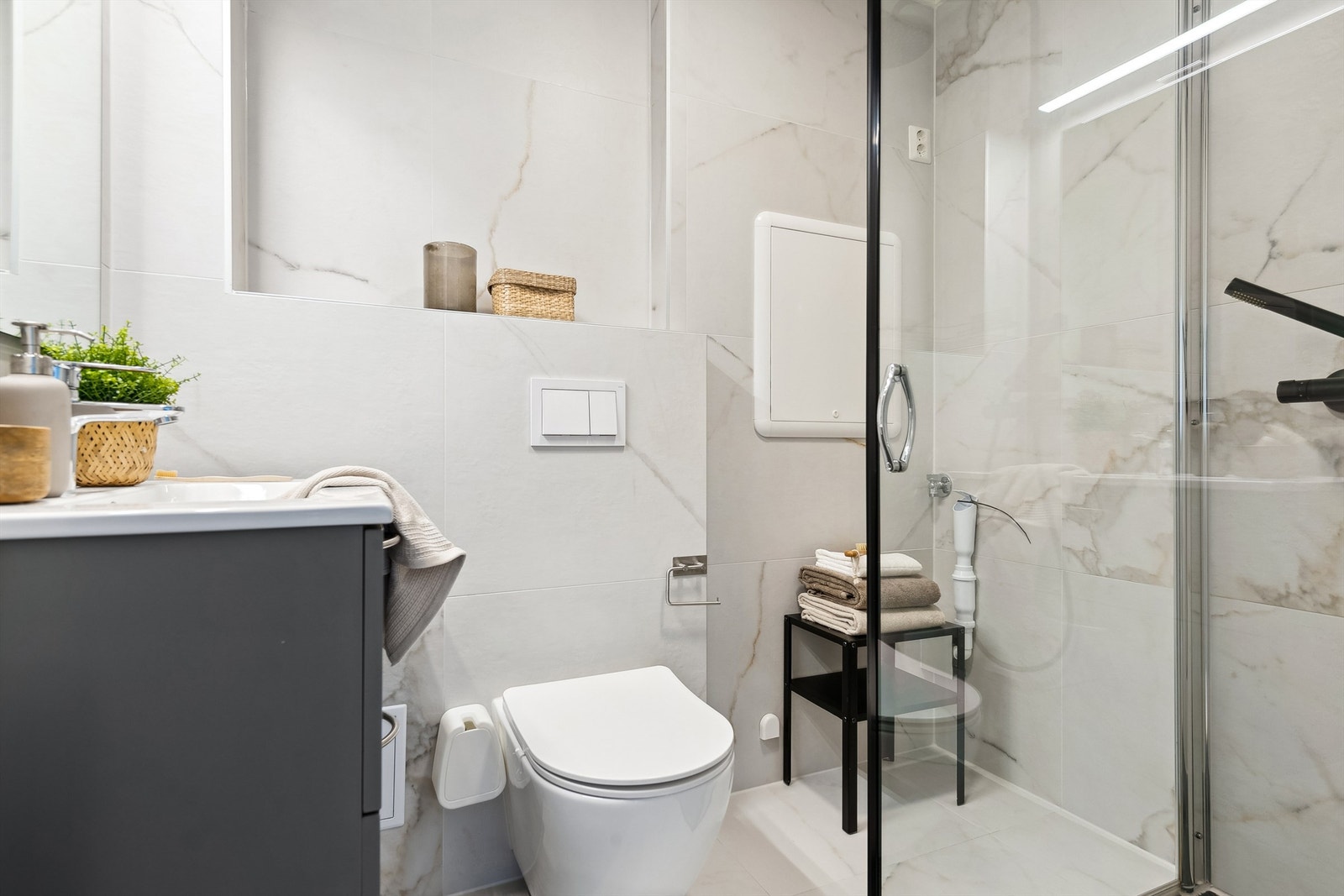 Lyst og innbydende bad fra 2022 med opplegg for vaskemaskin. Galleribilde