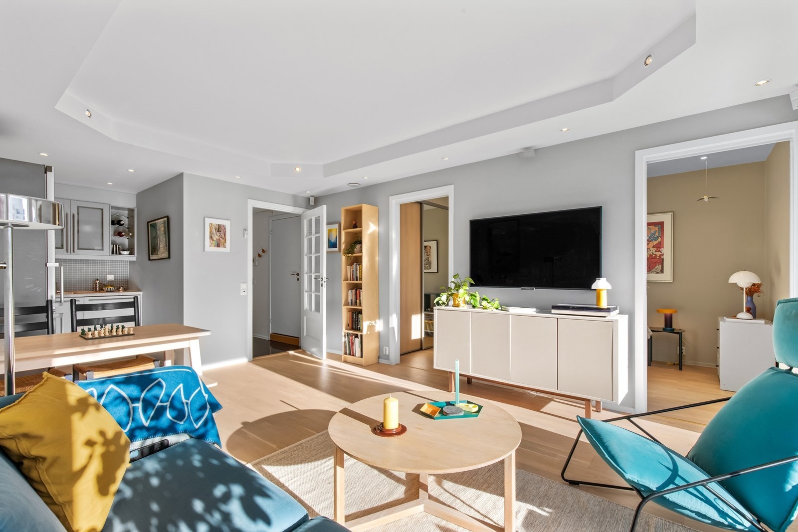 De store vinduene gjør at sol og lys fyller hele leiligheten. Parkettgulvene ble slipt og lakkert i 2025. Galleribilde