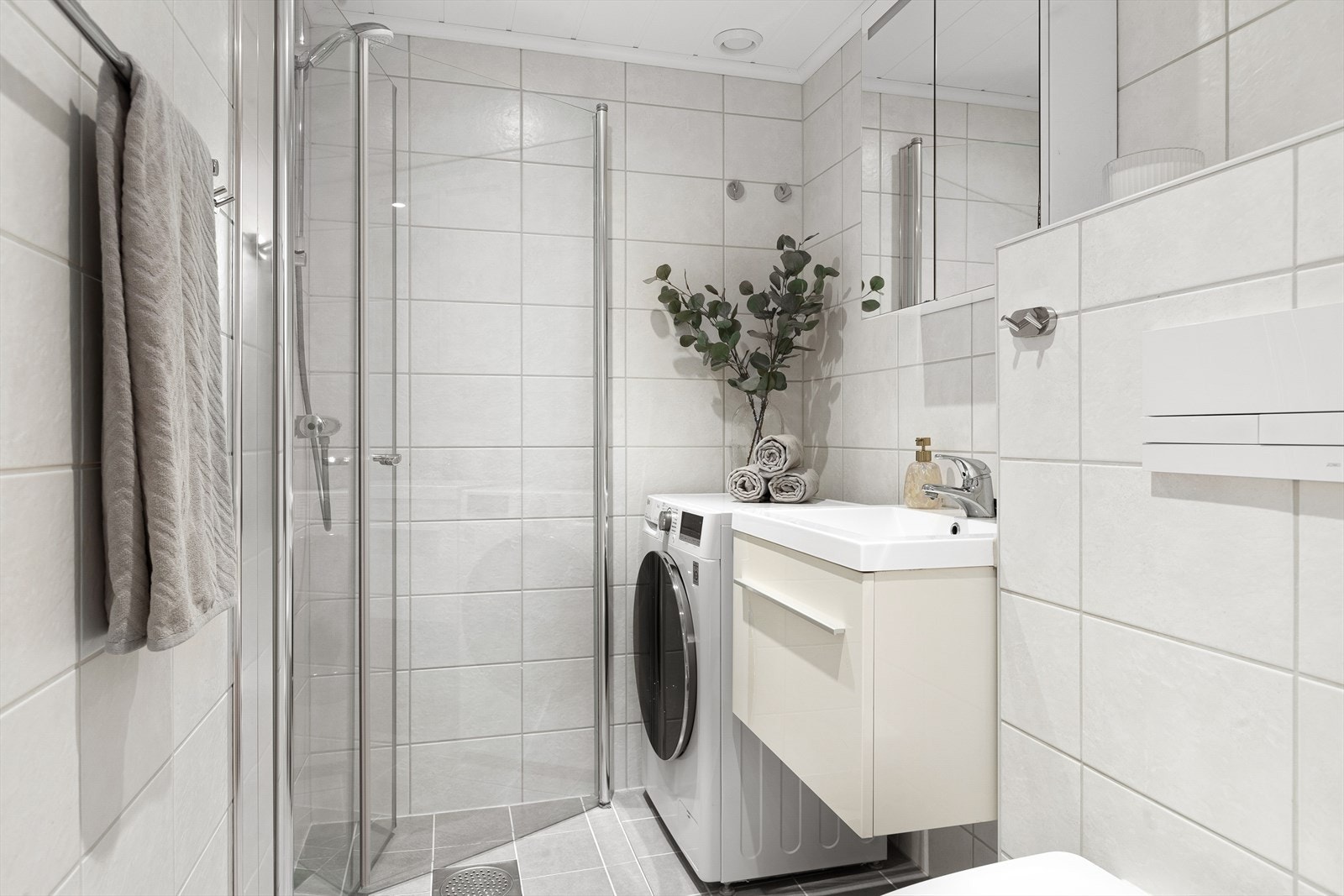 Badet er utstyrt med servant med underskap, speilskap, dusjnisje med innfellbare dører og toalett Galleribilde