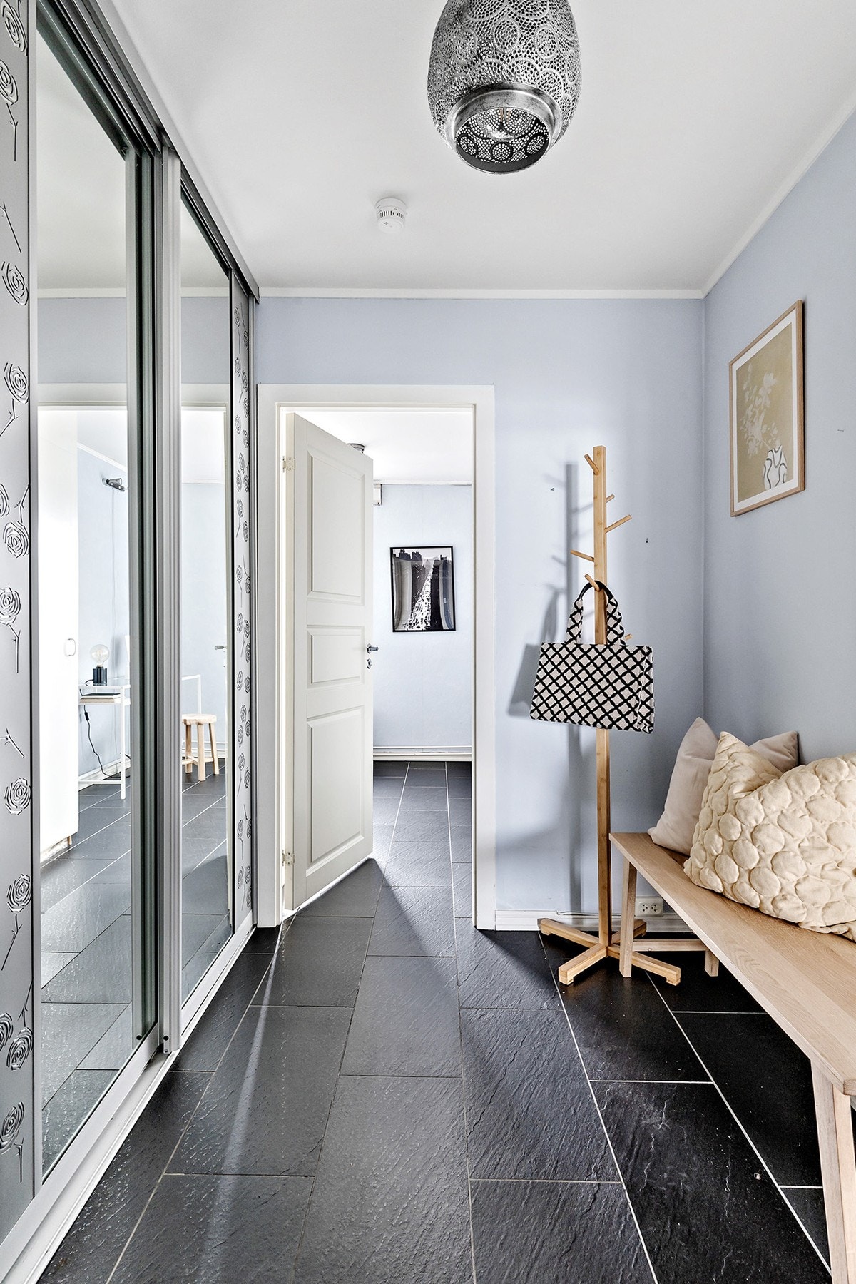 Lys og romslig entré med fliser på gulv. Stor skyvedørsgarderobe med speilfronter med rikelig oppbevaringsplass. Galleribilde