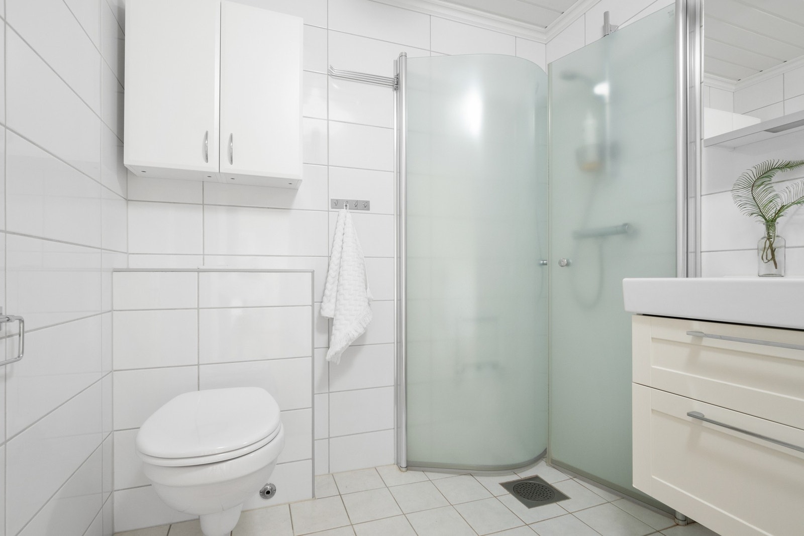 Badet har vegghengt toalett og et dusjhjørne med innfellbare vegger. Galleribilde