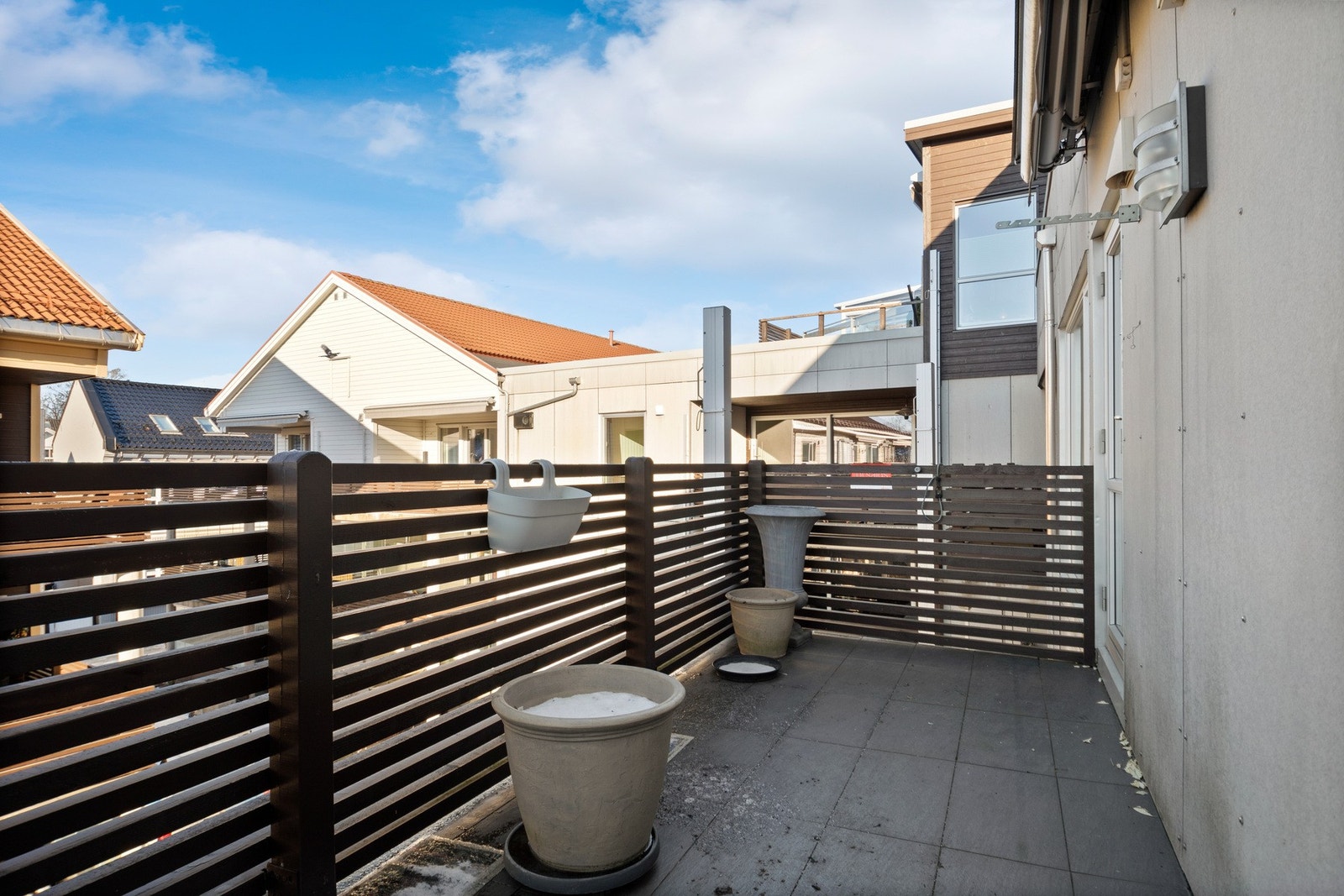 Balkongen har flislagt gulv, belysning og utestikk. Galleribilde