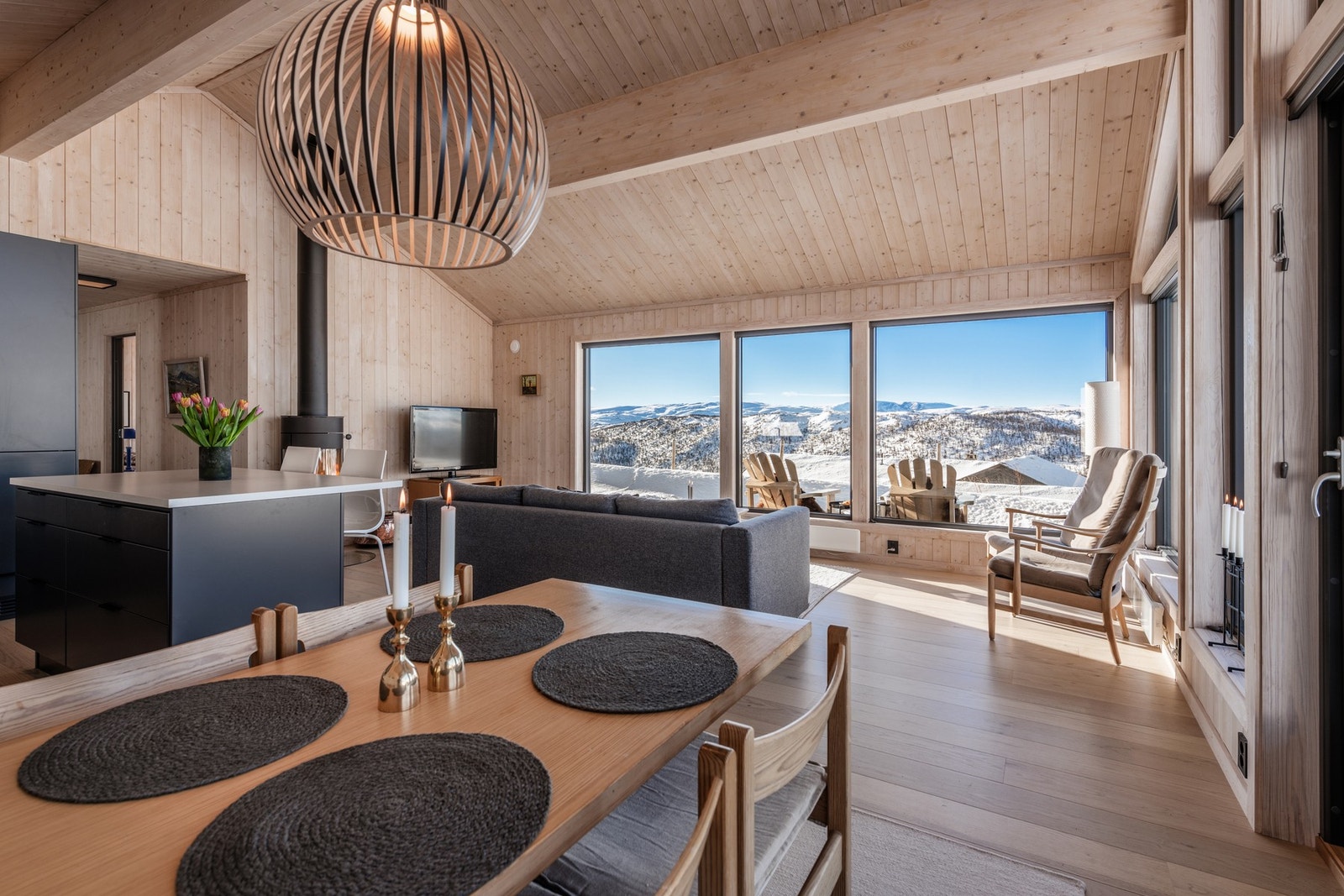 Stuen er omringet av store vinduer med solavskjerming. Galleribilde