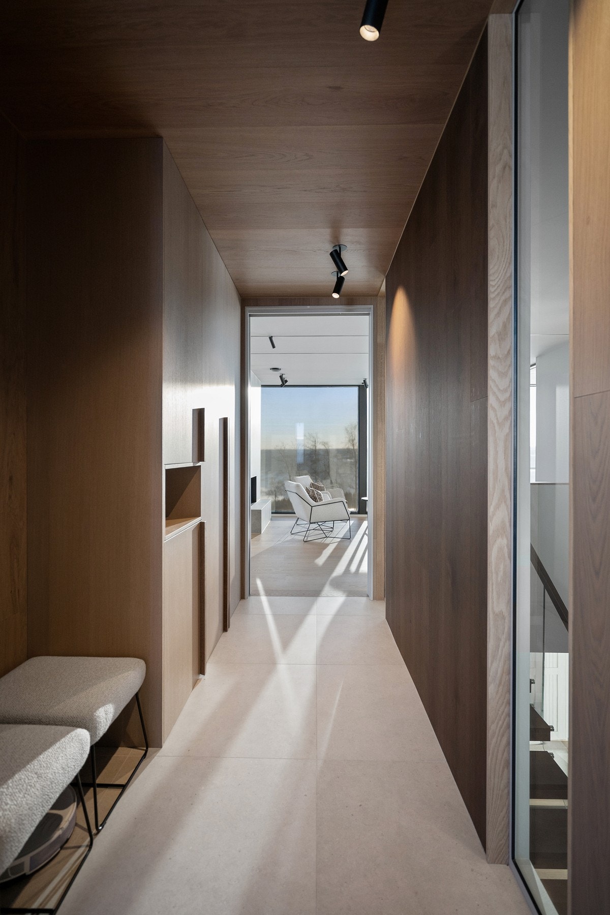 Romslig og lekker flislagt gang/inngangsparti med høy, flott, spesialtilpasset inngangsdør med døråpner og gode plassbygde garderobeløsninger Galleribilde