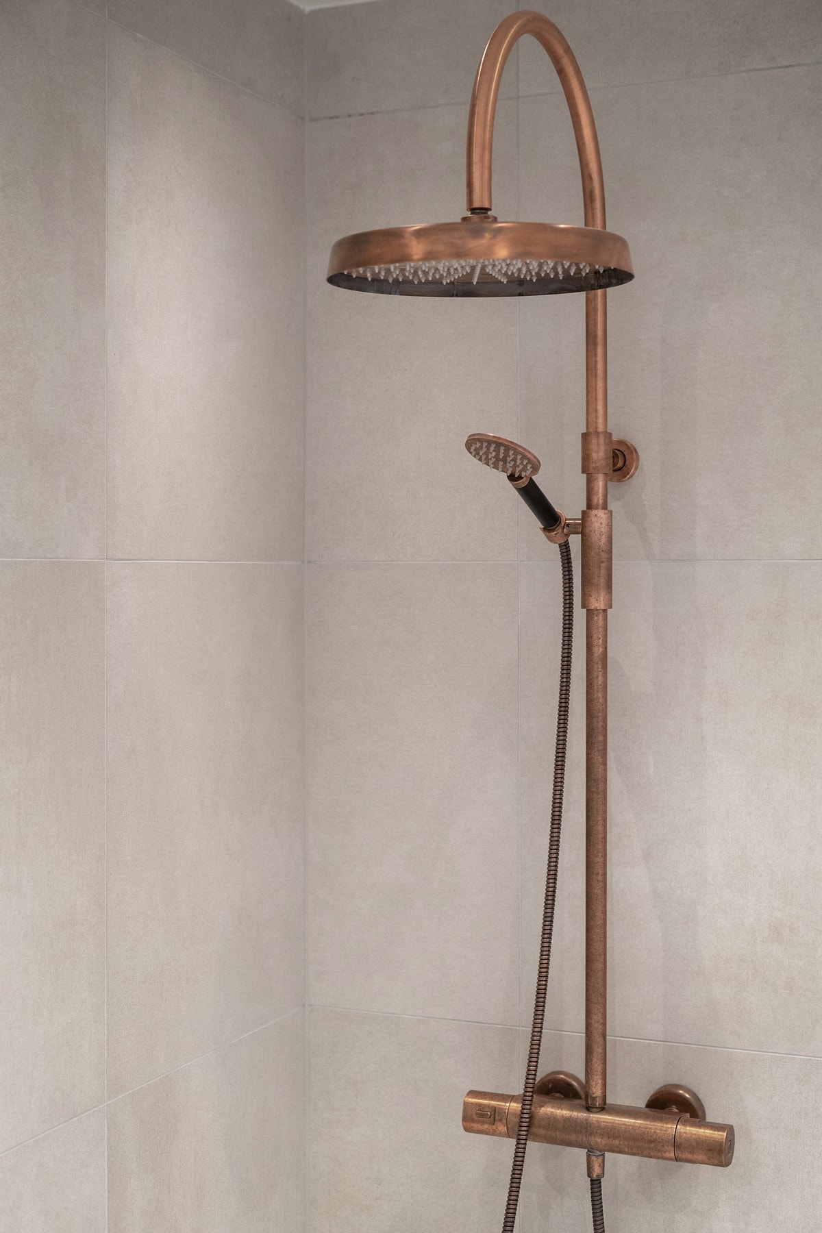 Dusj med regnfallsdusjhode og hånddusj i bronseutførelse. Galleribilde