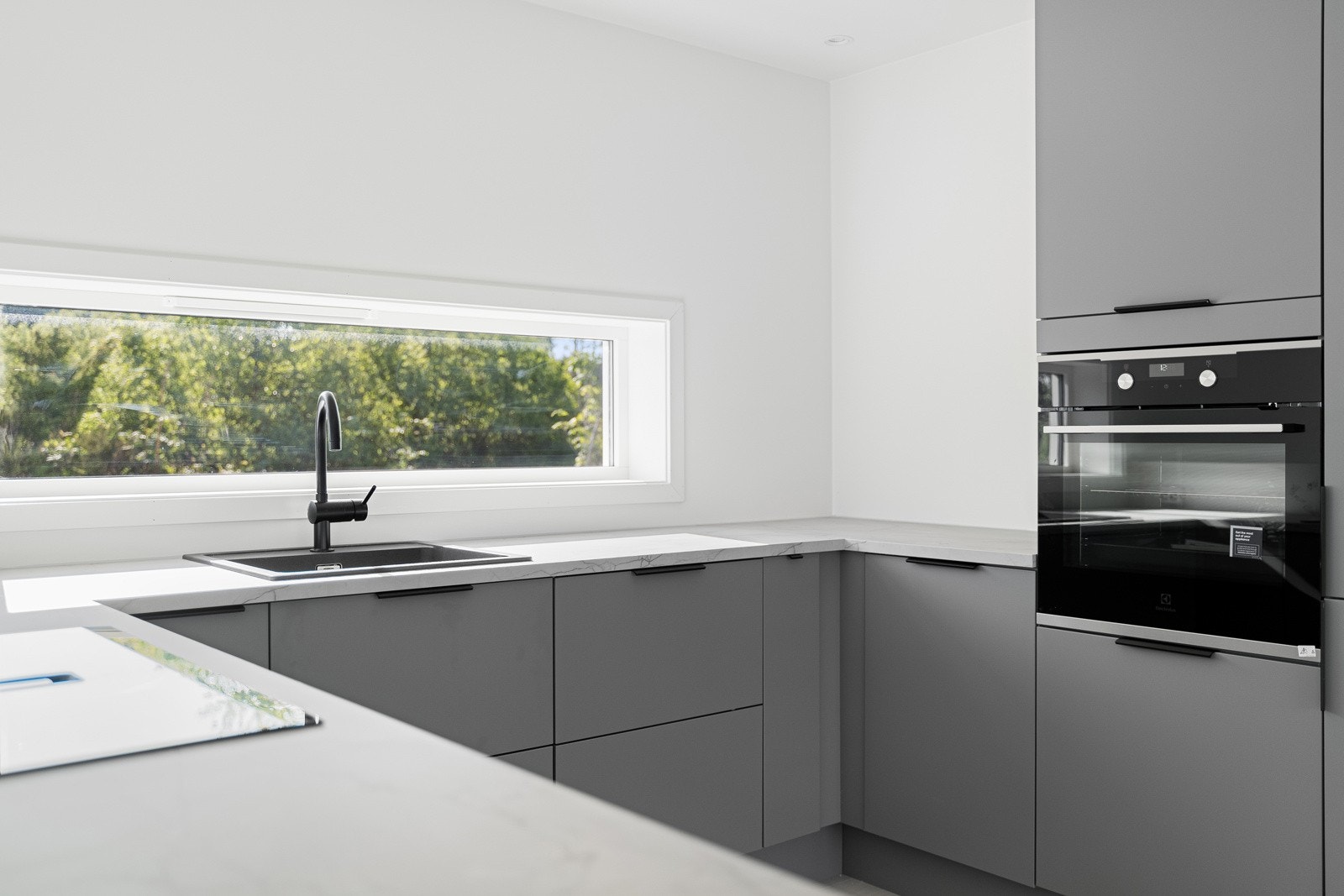 Stilrent kjøkken med induksjonstopp m. integrert avtrekksvifte Galleribilde