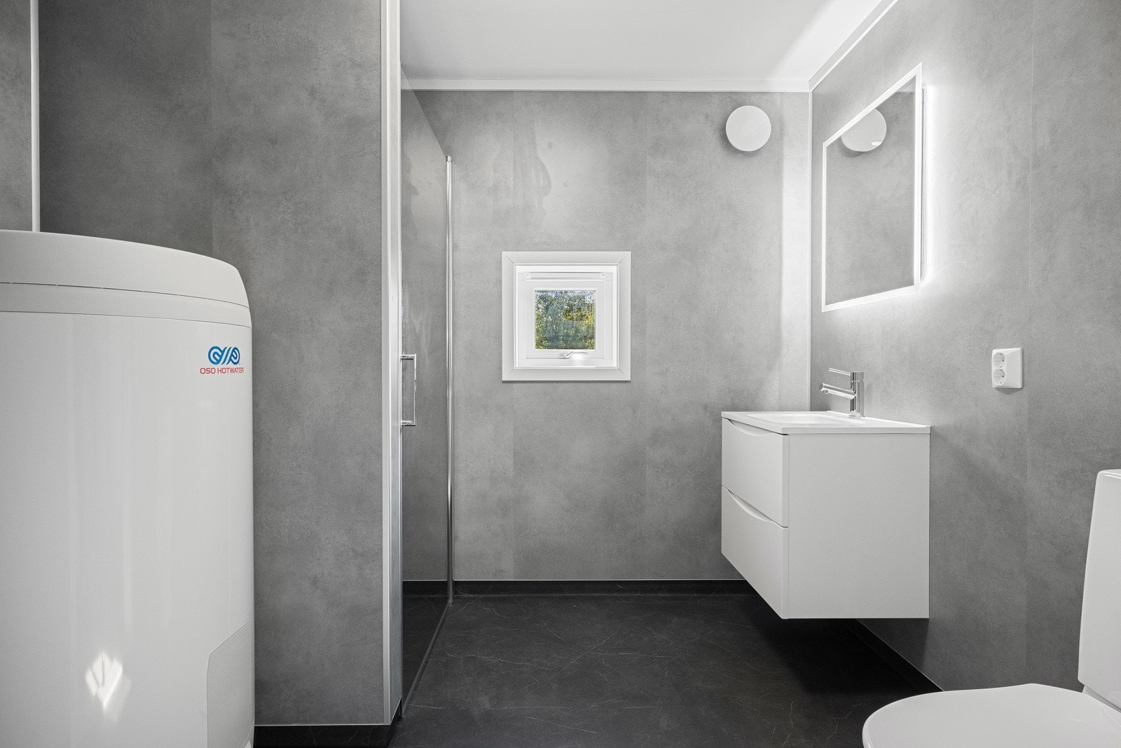 Bad med wc, dusj i nisje, servant med skap.Speil med belysning Galleribilde