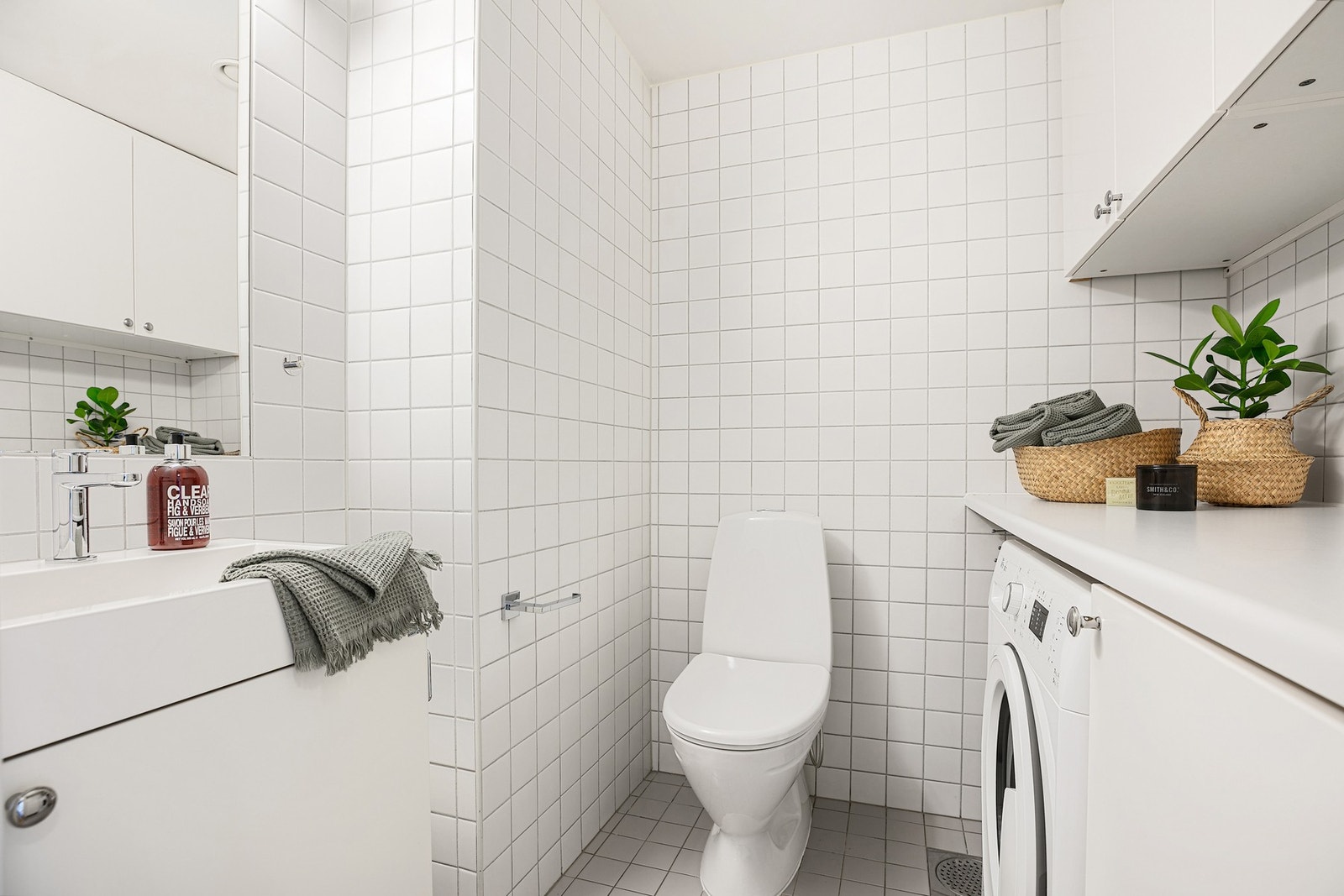 Et vaskerom/wc fra byggeår er innredet med toalett, servant med underskap og opplegg for vaskemaskin Galleribilde