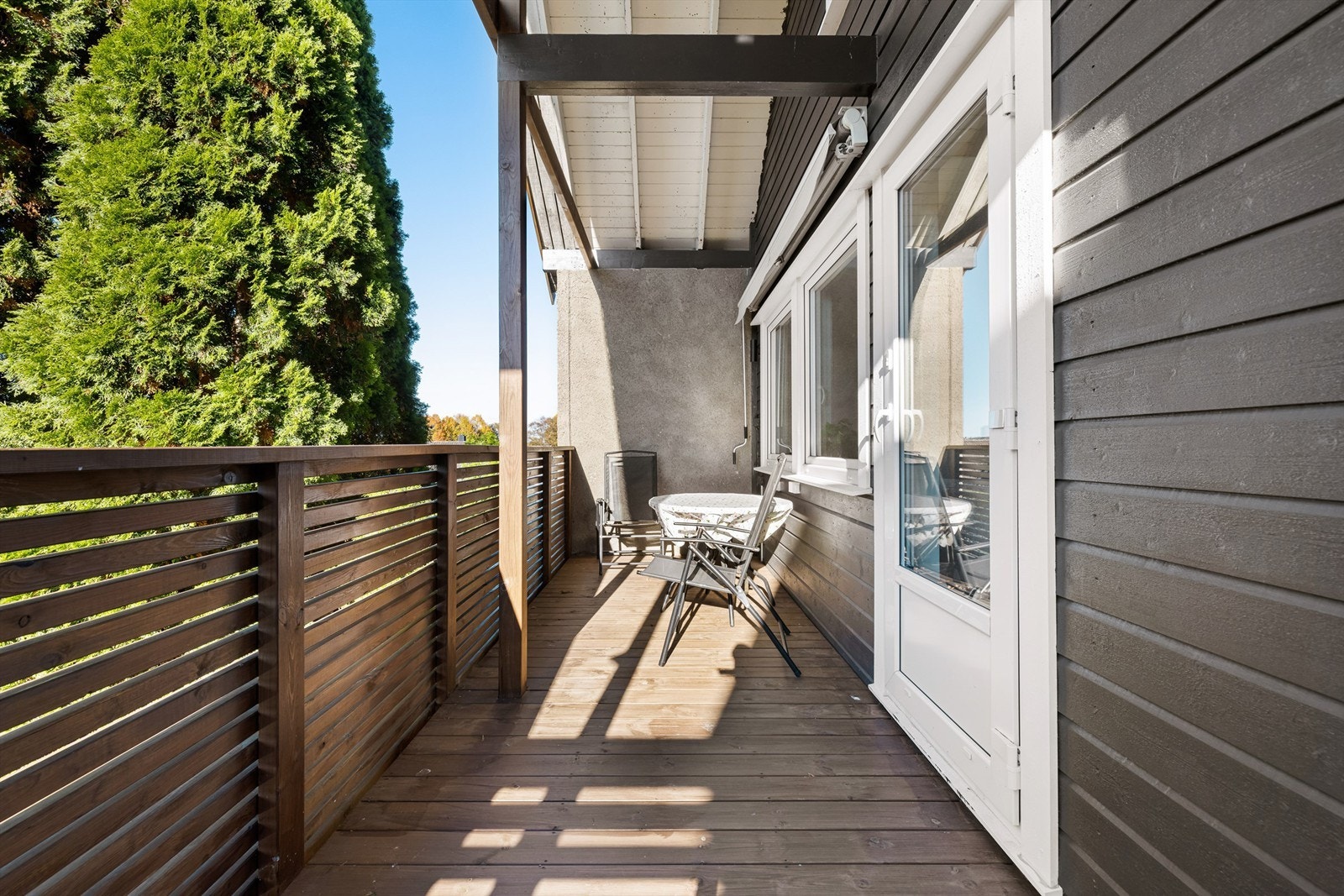 Terrassen utnytter hele etasjens bredde, overhengende yttertak har lunende effekt. Galleribilde