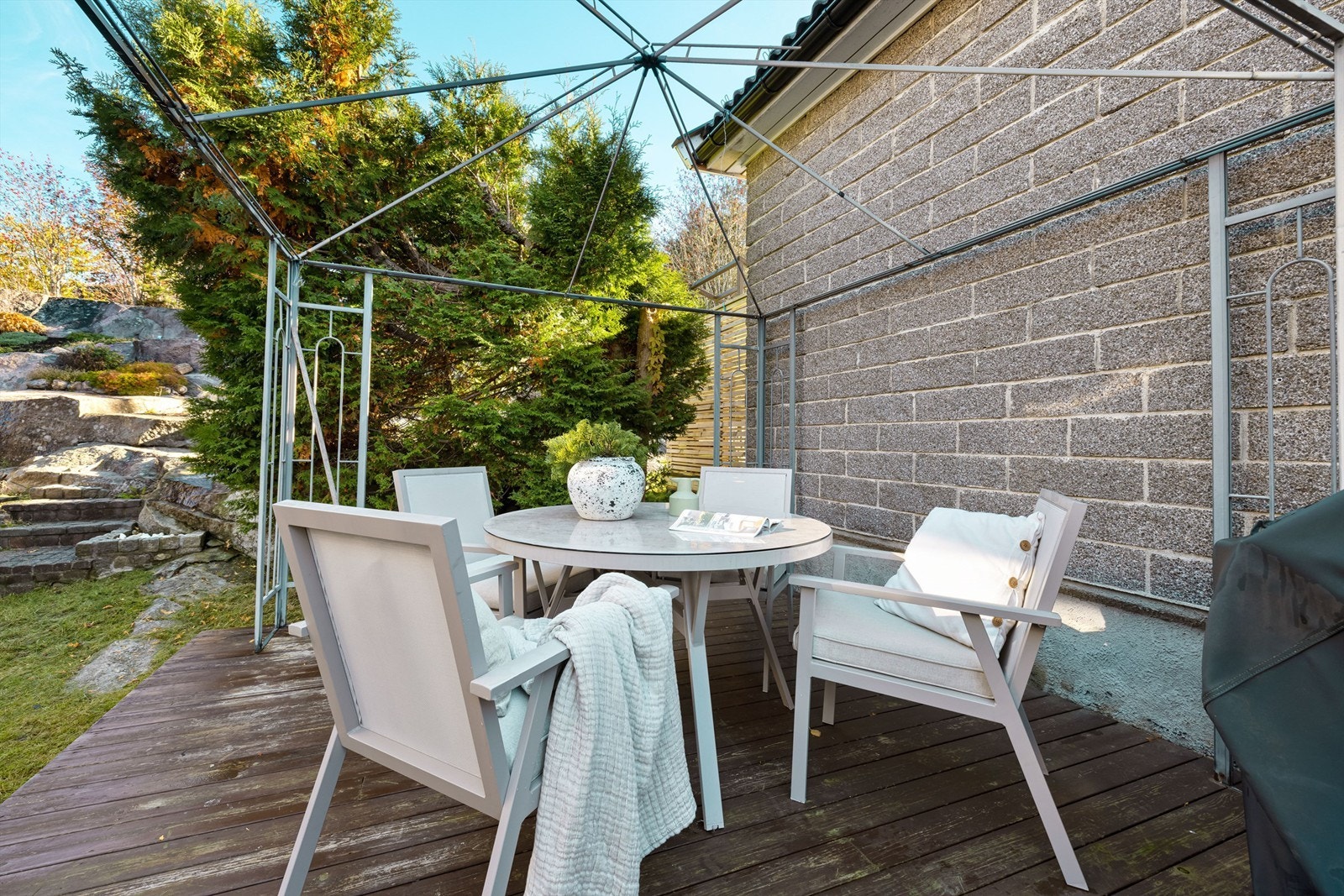 To plattinger er anlagt foran boligens østre side, denne med paviljong og mulighet til å sitte ute i lune omgivelser. Galleribilde