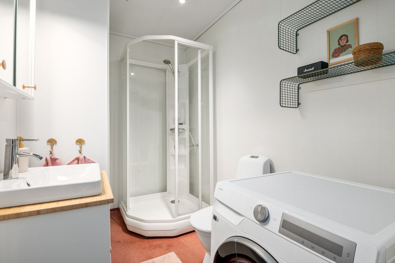 Badet er utstyrt med dusjkabinett, mekanisk avtrekk, opplegg for vaskemaskin, servant og wc. Galleribilde