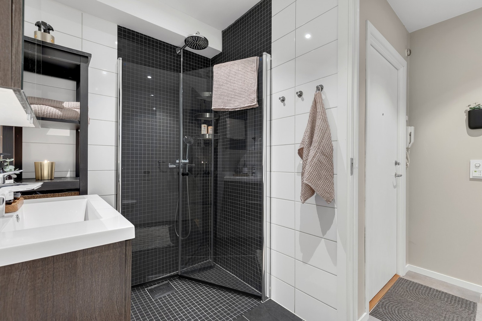 Dusjsonen har dekorative flis og praktiske, plassbesparende dører som frigjør plass på badet. Galleribilde