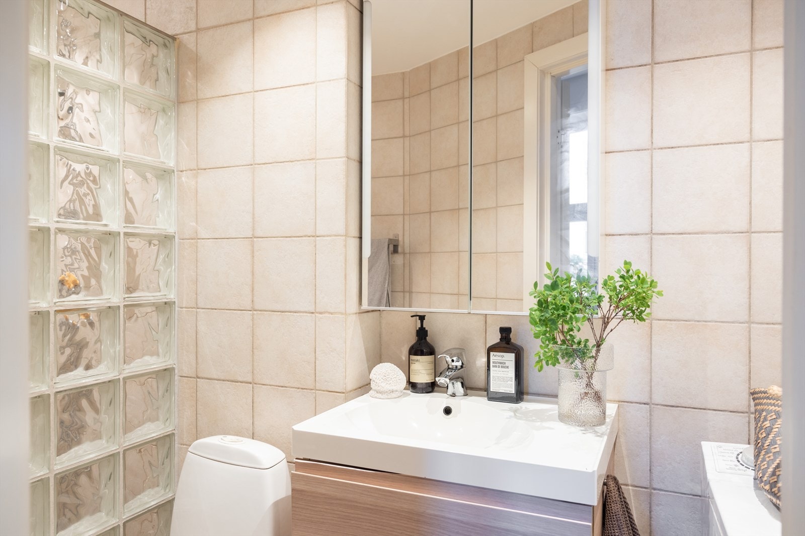 Badet er innredet med toalett, servant nedfelt i innredning og speilskap. Galleribilde