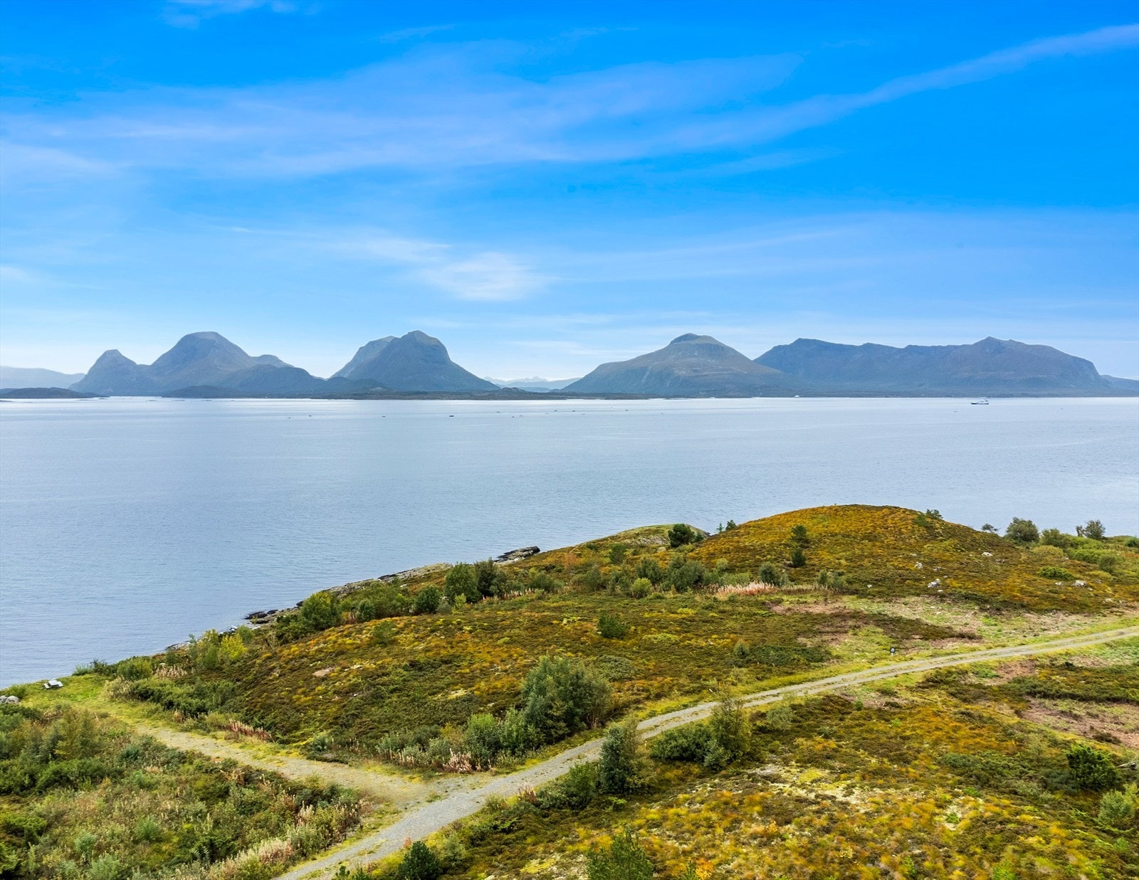 Velkommen til Edøya og Norddalsveien 54 - En fritidstomt som strekker seg over 2 mål, med fantastisk utsikt mot sjøen og nydelige Tustnatabban. Galleribilde