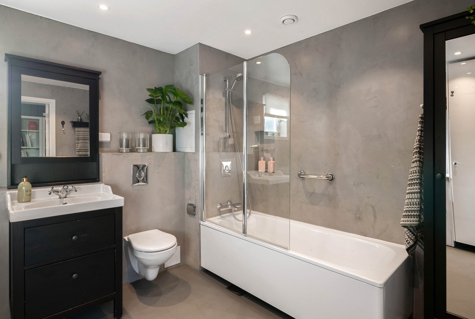 Lekkert bad med mikrosement på vegger og gulv, varmekabler i gulv og downlights i himling Galleribilde