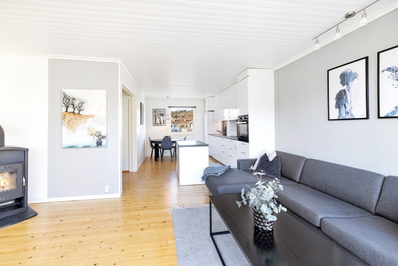 Lys og romslig stue med god plass til både sofagruppe og spisebord. Peisovn i stue. Galleribilde