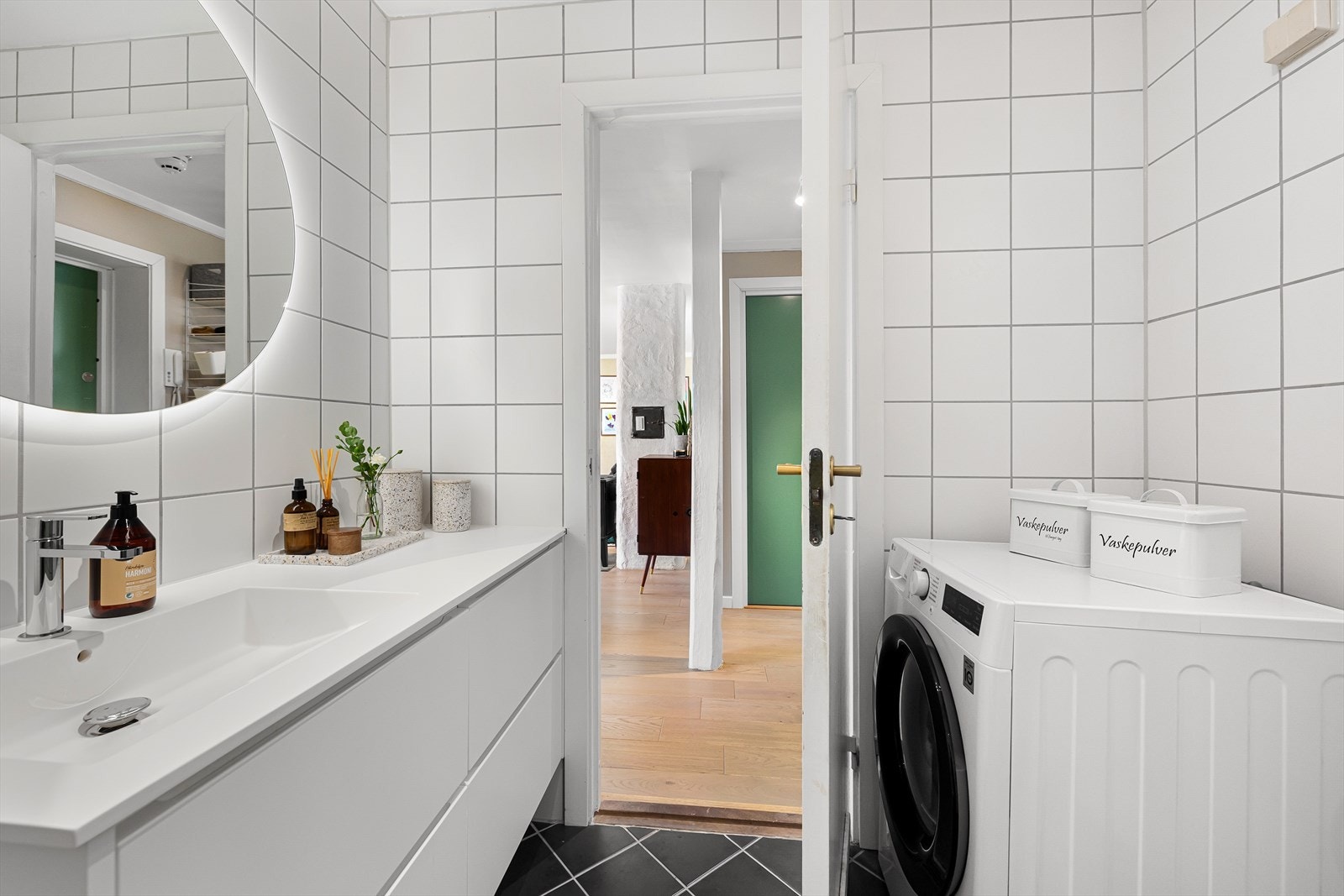 Rommet inneholder dusjhjørne med innfellbare dører i glass, vegghengt toalett med lav høyde og baderomsinnredning med nytt servantskap fra 2023, helstøpt benkeplate, speil på vegg og vask med ett-greps blandebatteri. Galleribilde