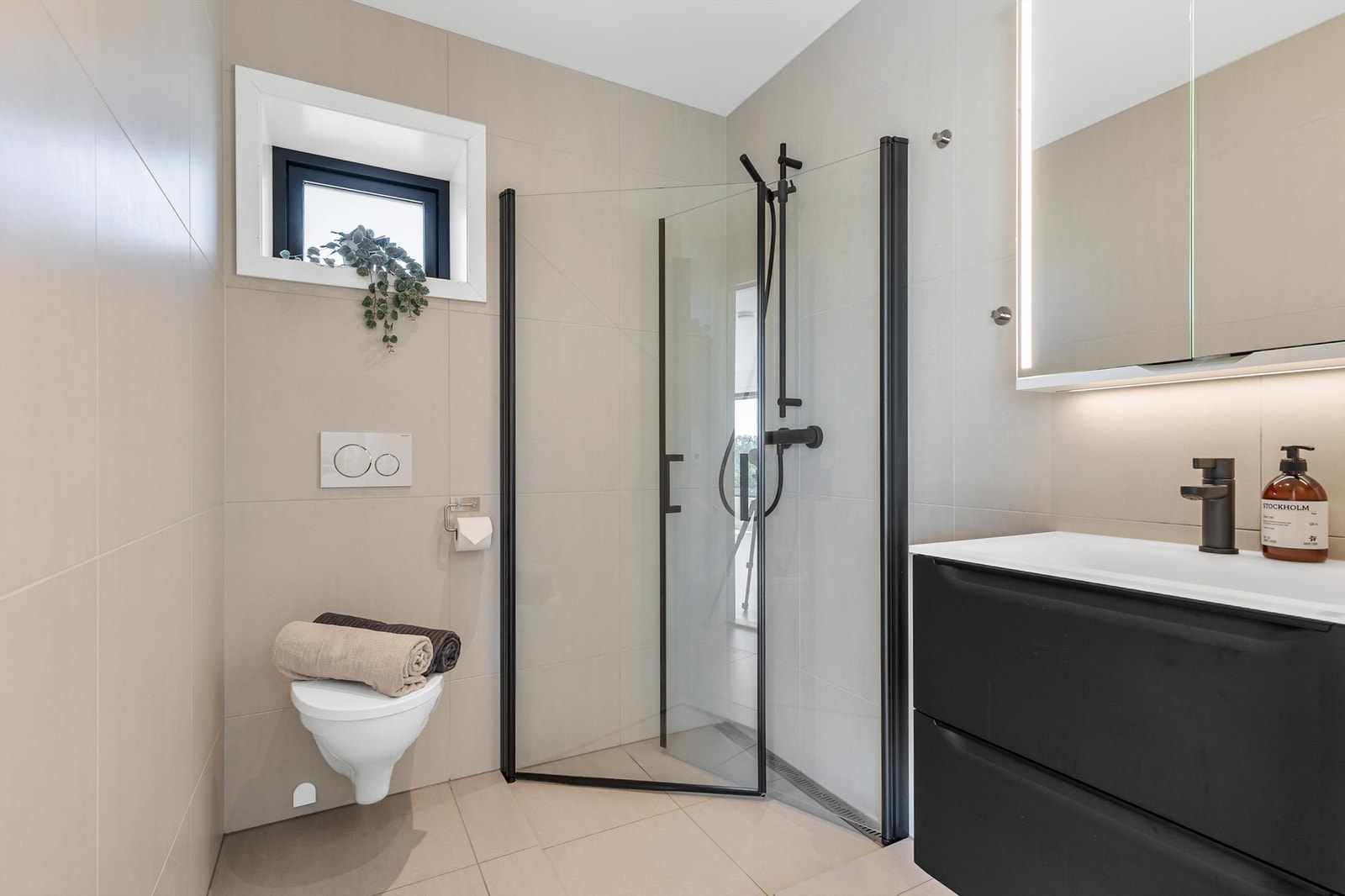 Stilig bad i 1. etasje fra byggeår i 2022. Flislagt gulv og vegger i moderne utførelse med varme i gulvet. Galleribilde