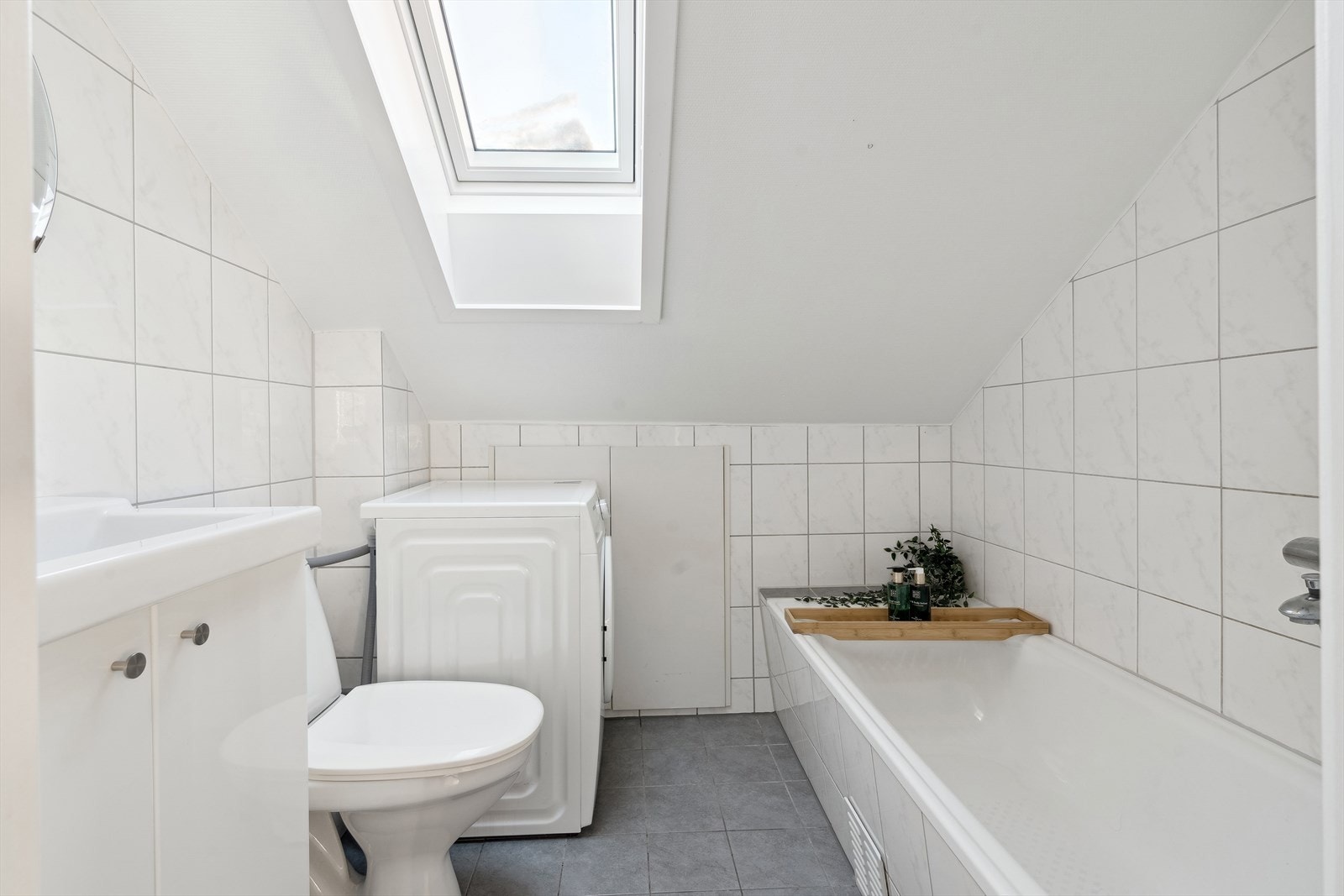 Badet inneholder toalett, badekar med dusj og servant med skapinnredning. Det er også opplegg for vaskemaskin. Galleribilde