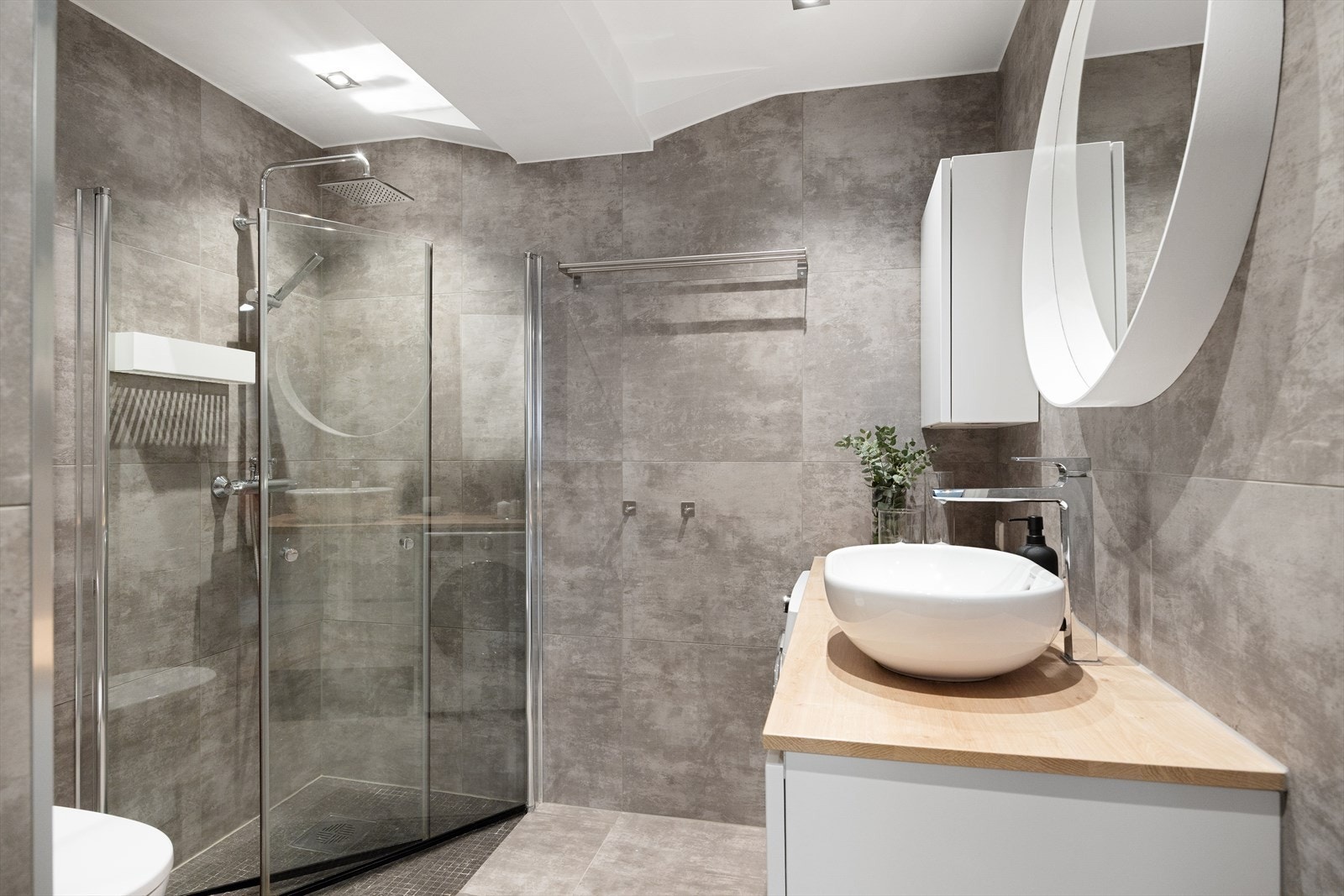 Delikat flislagt baderom med downlights i himlingen og gulvvarme. Badet, opprinnelig fra 1996, ble modernisert i 2016 med "flis på flis"-løsning. Galleribilde