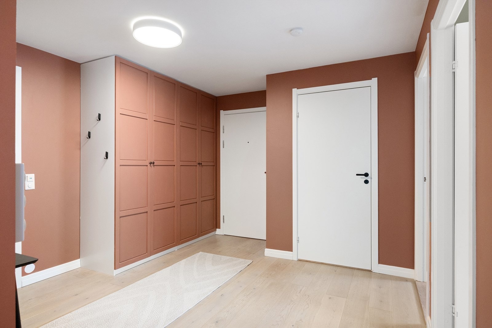 Leiligheten har en romslig og innbydende entré, hvor den hvitpigmenterte 1-stavs eikeparketten gir et friskt førsteinntrykk. Den praktiske garderoben gir god plass til å henge fra seg yttertøyet. Galleribilde