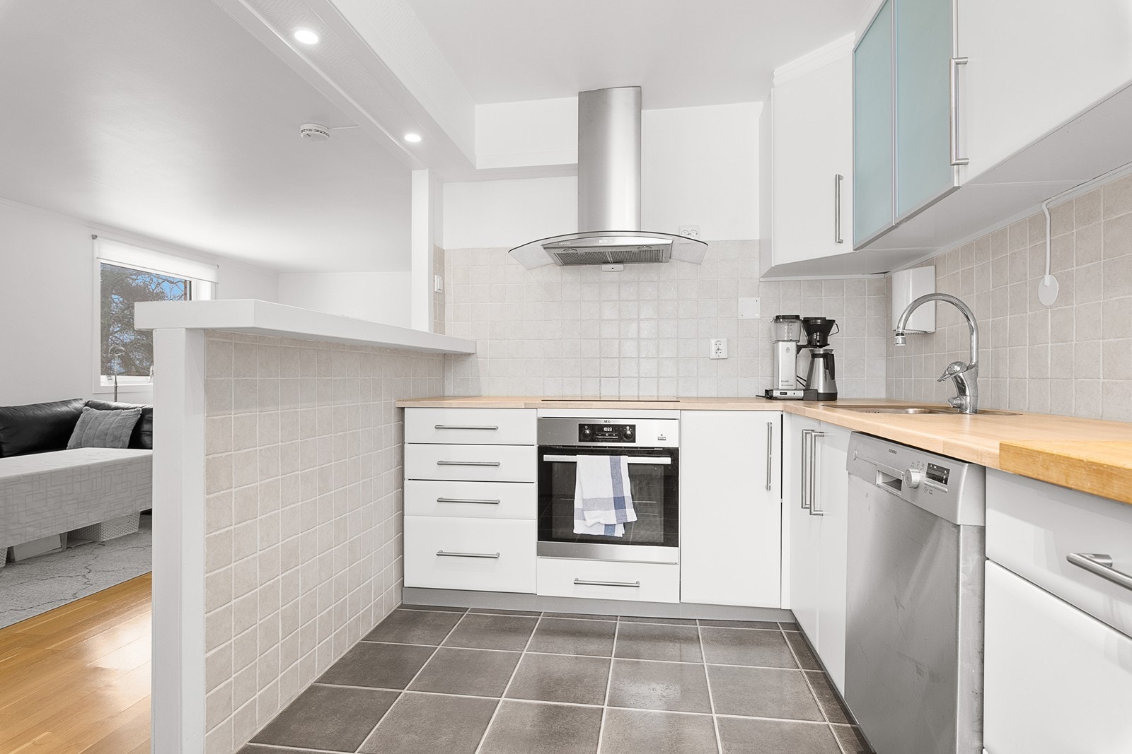 Kjøkkenet har pen innredning med hvite fronter - hvitevarer medfølger Galleribilde