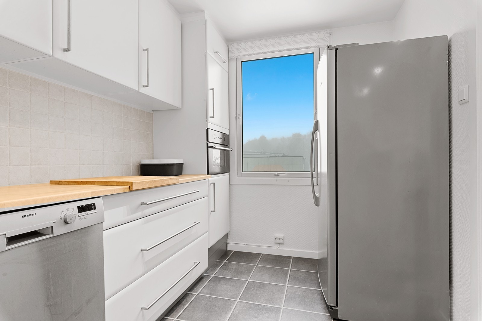 Godt med naturlig lys på kjøkkenet - integrert mikrobølgeovn i høyskap Galleribilde