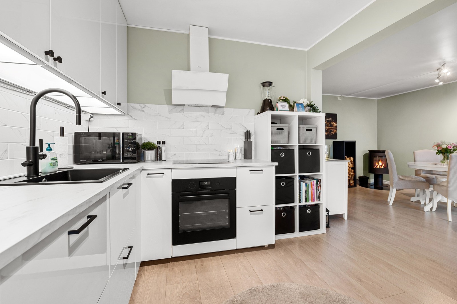 Kjøkkenet har hvite, flate fronter med integrerte hvitevarer. Galleribilde