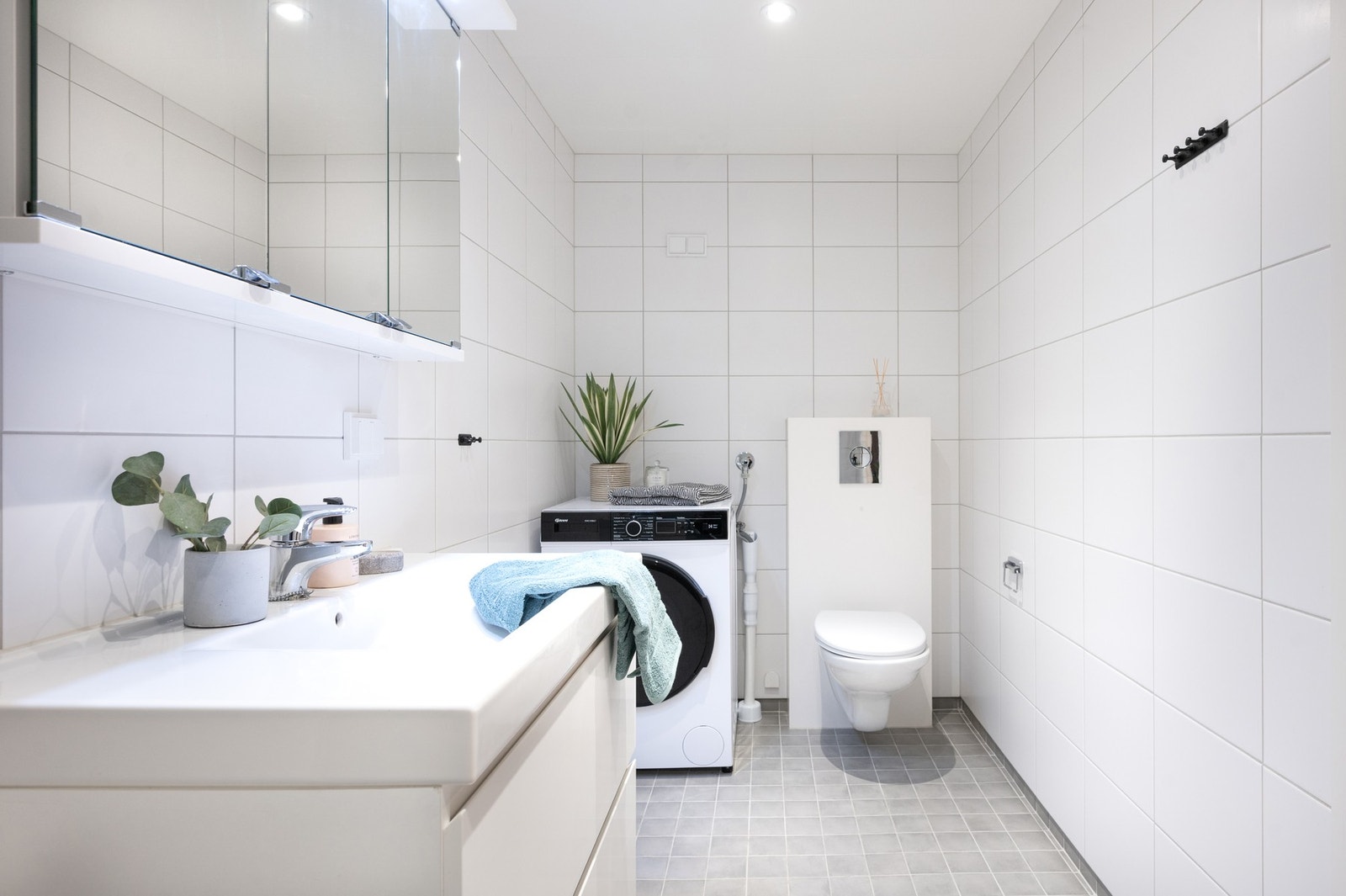 Rommet er innredet med vegghengt servantinnredning, speilskap, en romslig dusjnisje, toalett og opplegg for vaskemaskin. Galleribilde