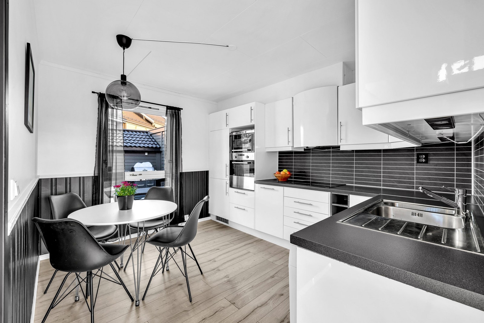 Stilrent IKEA kjøkken fra 2010 med hvite, glatte fronter og laminert benkeplate. God belysning og smarte stikkontakter under overskap Galleribilde