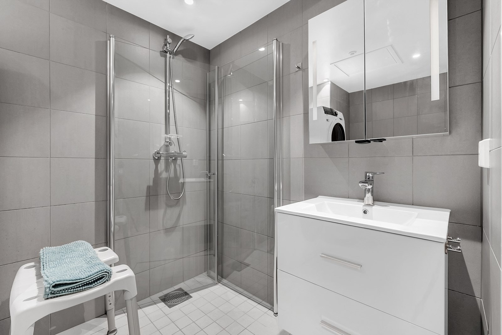 Stilrent bad med dusjhjørne og god oppbevaringsplass. Galleribilde