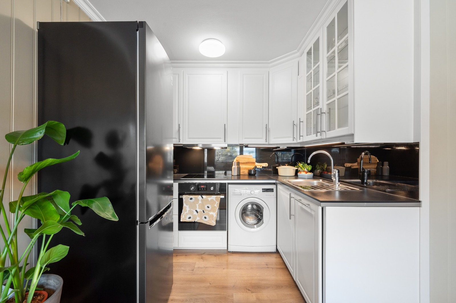 Hvitt, stilrent kjøkken med profilerte fronter. Kjøkkenvifte byttet i 2025, ihht. vedtekter. Galleribilde