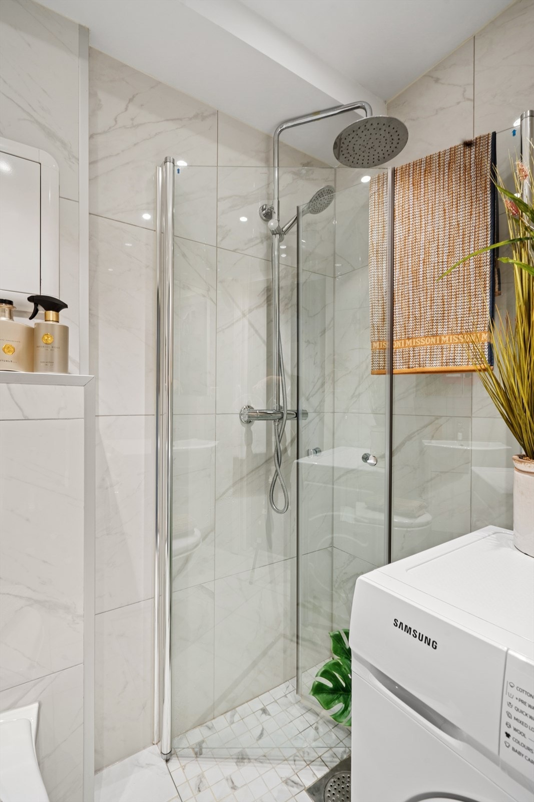 Dusjsonen er utstyrt med stilrene, svingbare glassvegger. Det er opplegg for vaskemaskin. Galleribilde