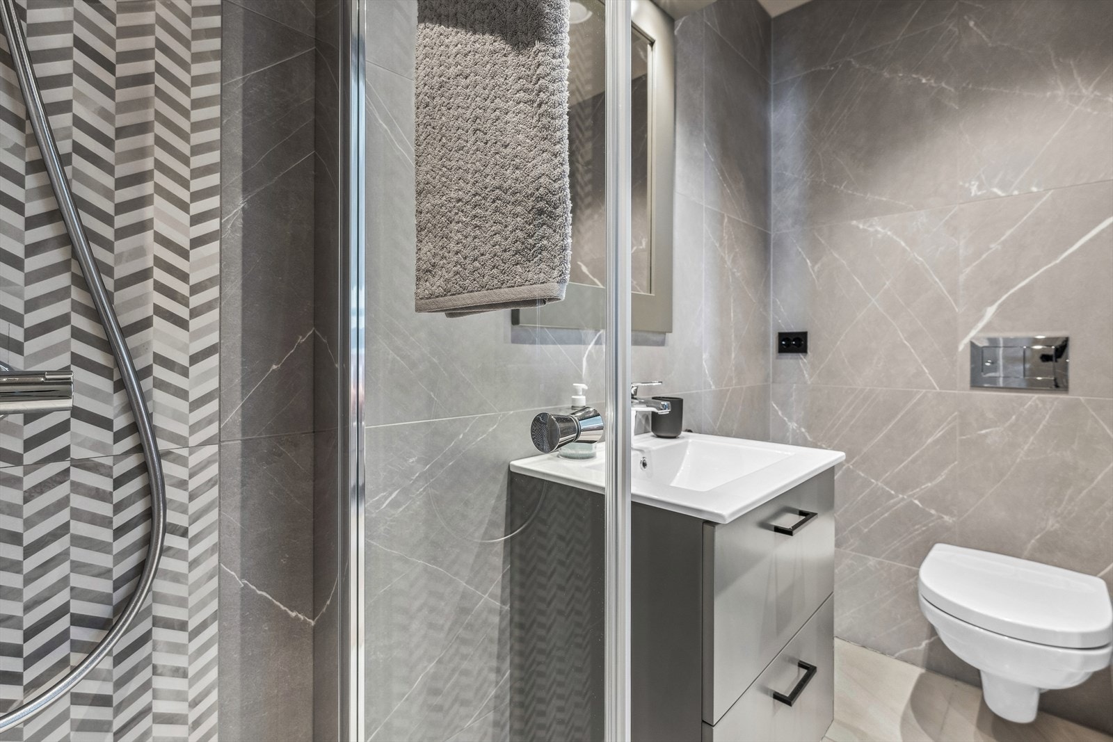 Bad 2/dusjbad med flislagte vegger og malte plater i himling. Utstyrt med servantskap med helstøpt servantplate, veggmontert klosett og dusjnisje med glassdører. Galleribilde