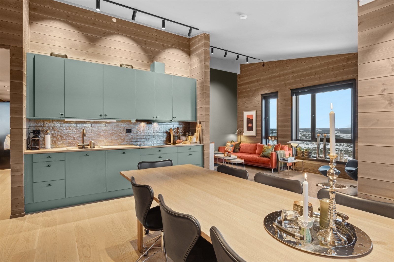 Stor spisegruppe og et funksjonelt kjøkken i en åpen og luftig planløsning. Galleribilde