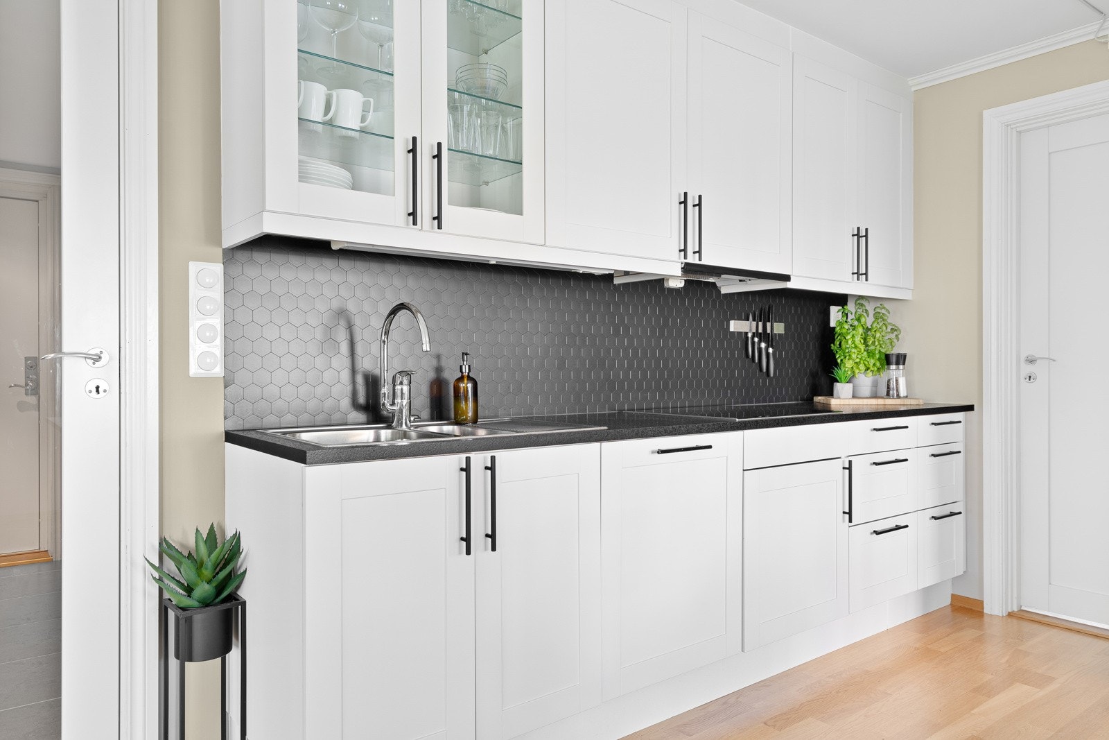 Det er lagt fliser mellom kjøkkenbenk og overskap. Galleribilde