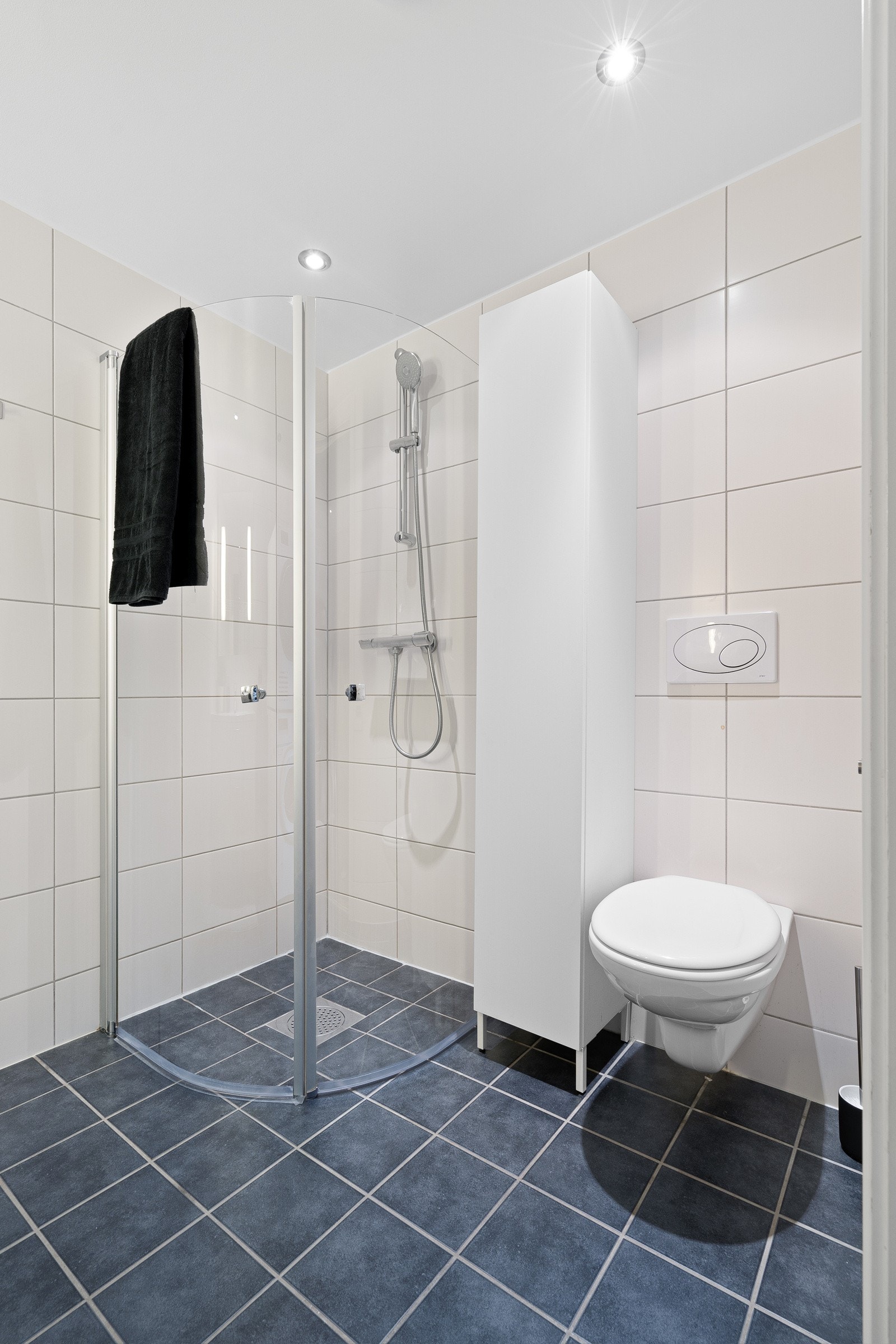 Pent flislagt baderom med gulvvarme. Badet er utstyrt med vegghengt toalett og dusjhjørne. Galleribilde