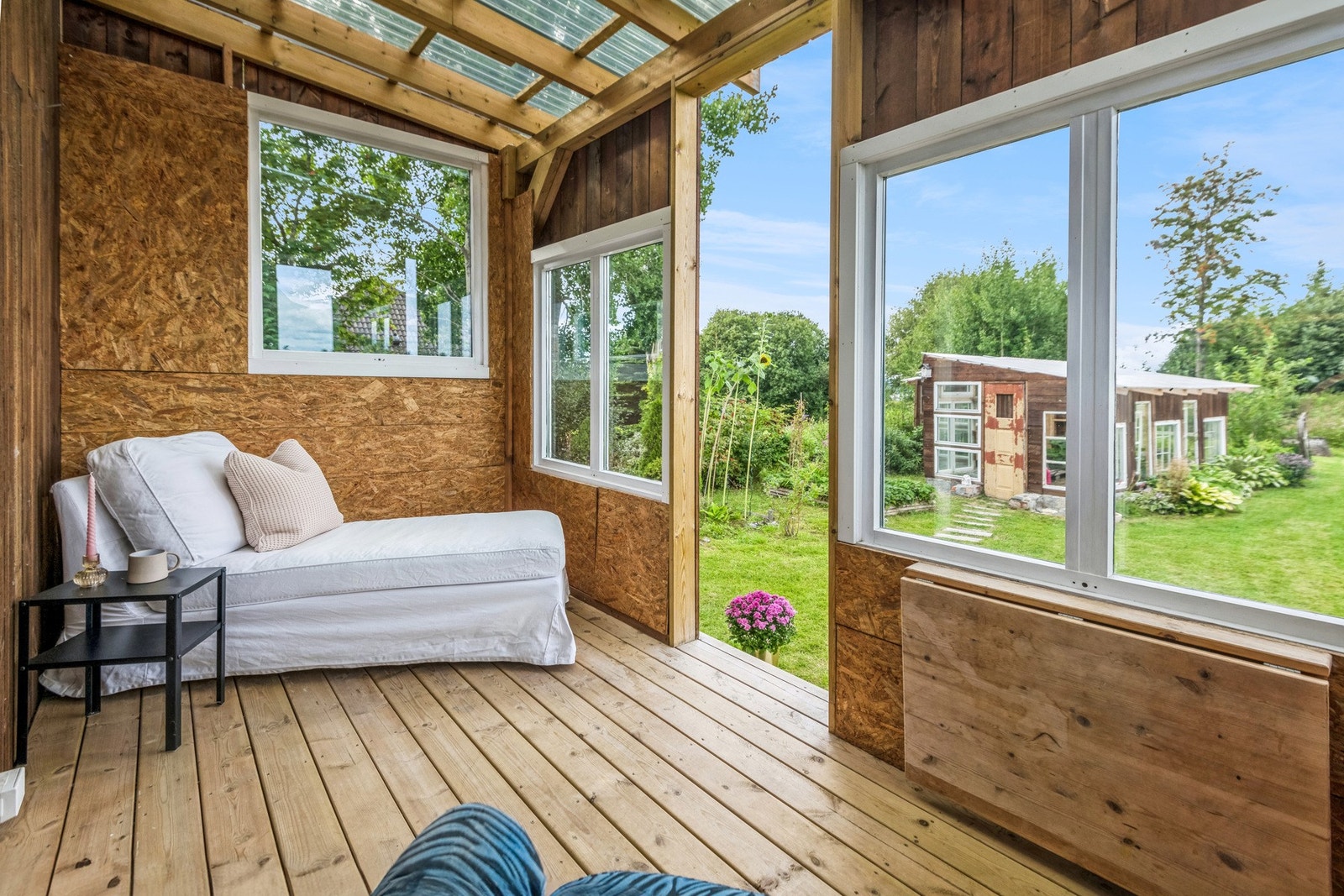 Takoverbygget veranda utenfor stua, hvor man kan sitte lunt og god skjermet for vær og vind. Galleribilde