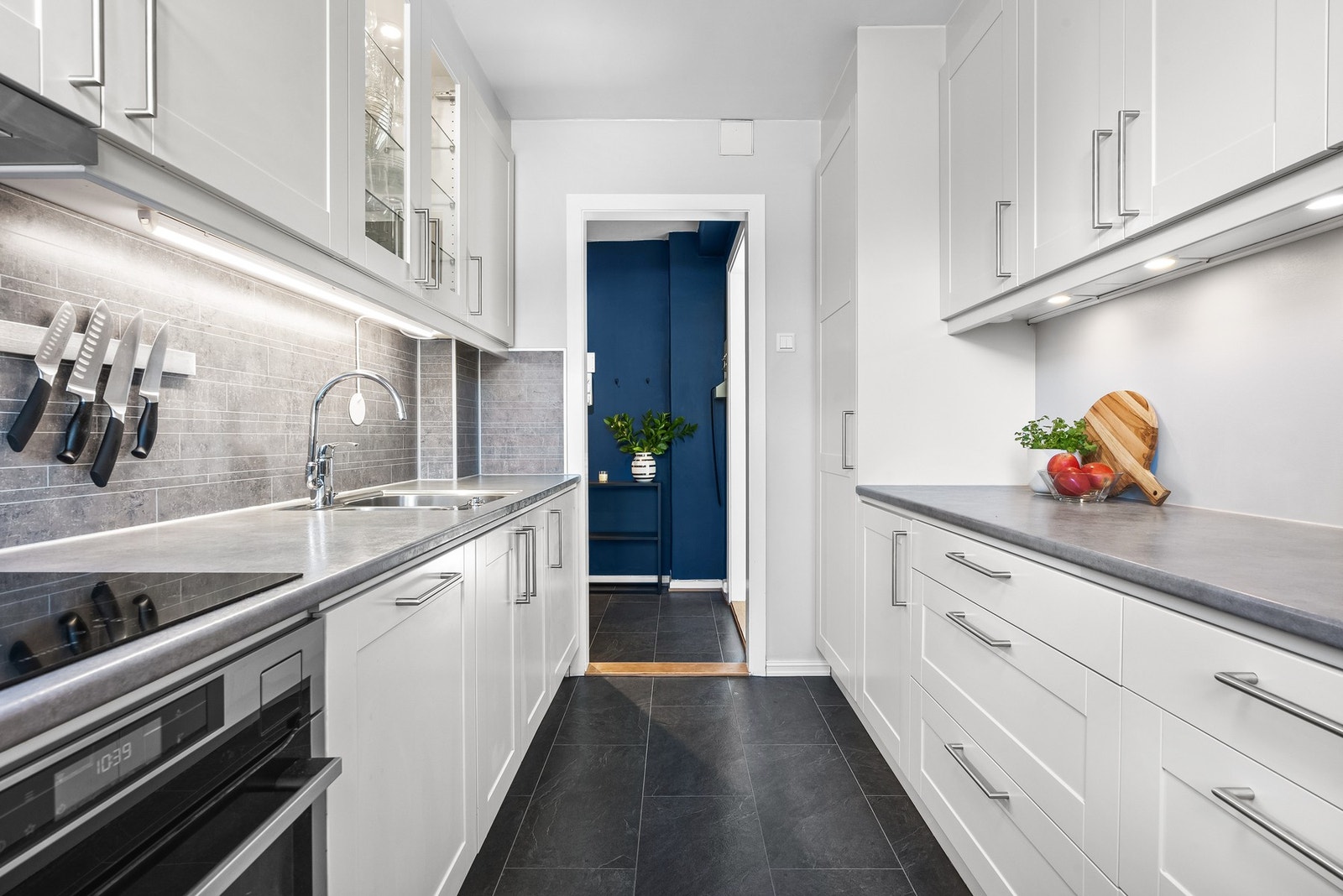 Innredningen er holdt i en klassisk stil med lyse rammefronter og noen vitrineskap med belysning, kombinert med grå benkeplate i laminat. Galleribilde