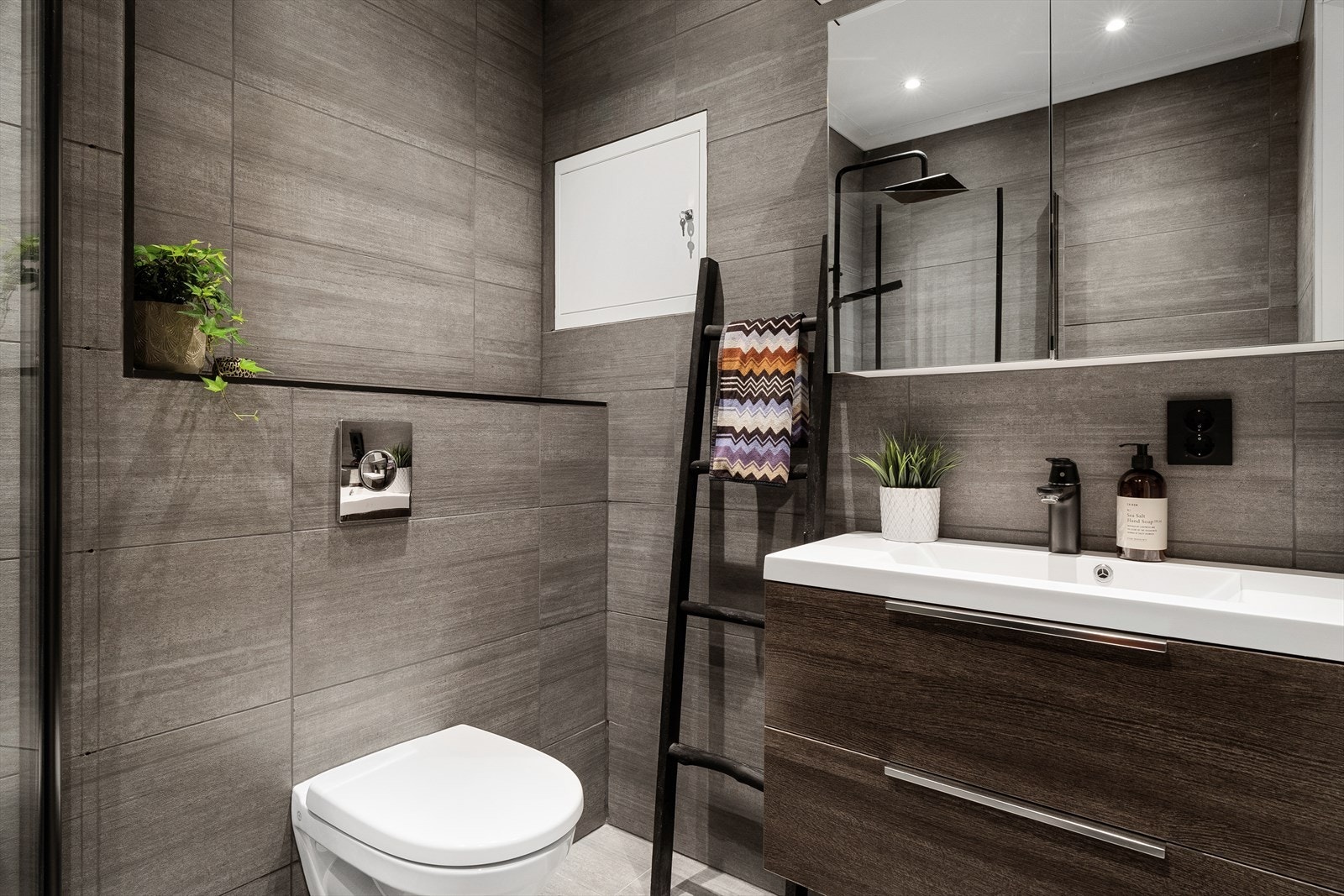 Badet, som ble oppusset i 2020, er lekkert og helfliset Galleribilde