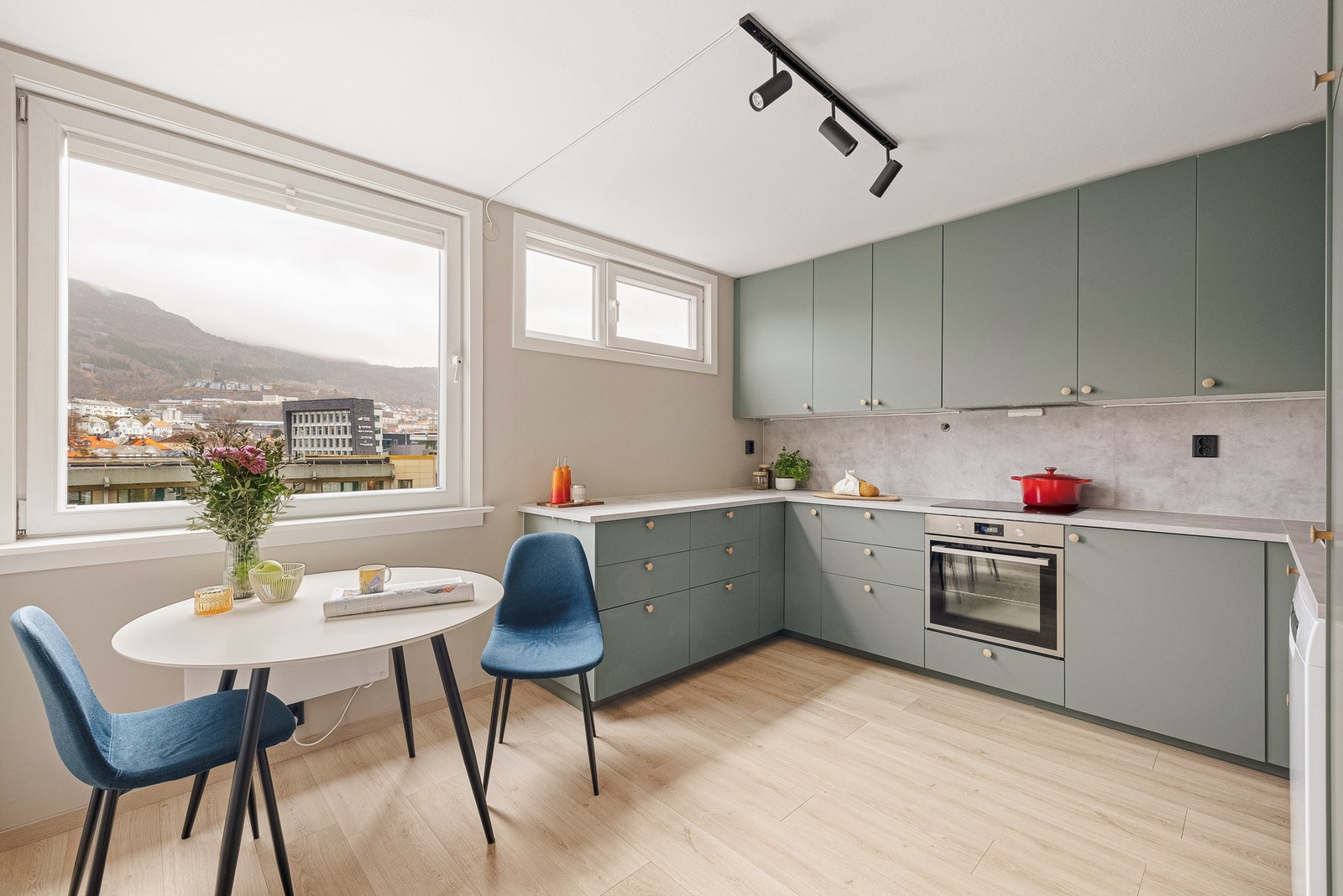 Kjøkkenet har innredning med slette fronter, laminat benkeplate og kompositt vaskekum Galleribilde