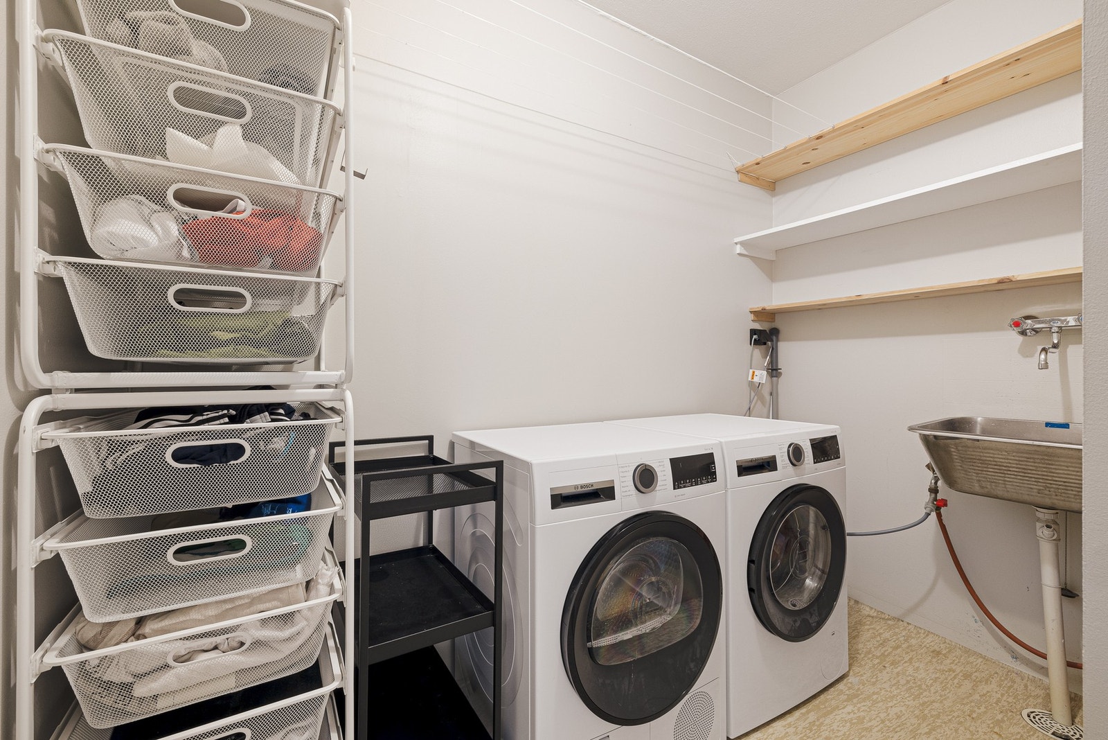 Vegg i vegg med badet har leiligheten et separat praktisk vaskerom som måler 4,8 m² Galleribilde