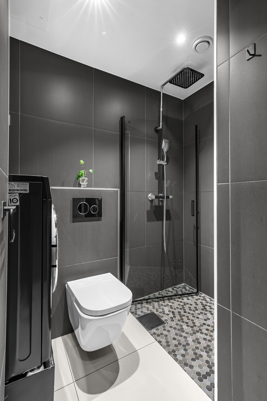 Den nedsunkede dusjnisjen med innfellbar dør i glass gir en følelse av romslighet og praktisk anvendelse. Galleribilde