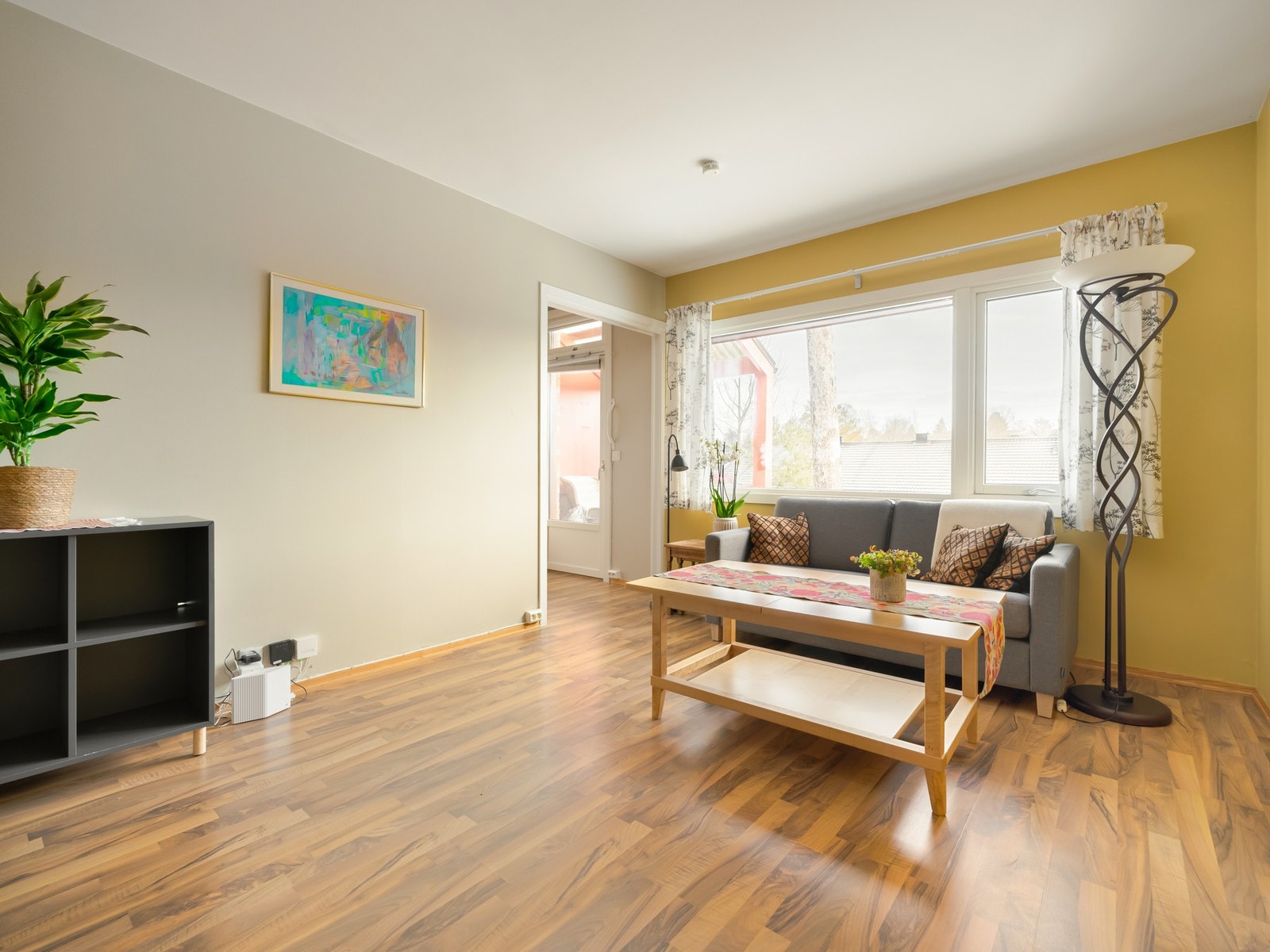 Stuen har store vindusflater ut mot hyggelige grøntområder. Galleribilde