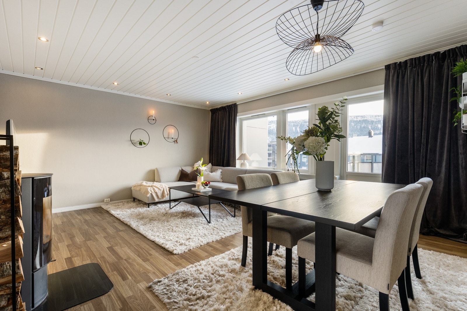 En lys og romslig stue med god plass til sofagruppe og spisebord med tilhørende møblement Galleribilde