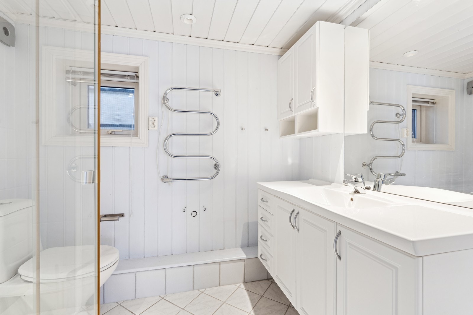 Badet er som resten av huset i klassisk stil med malt panel på vegger og tak. Galleribilde